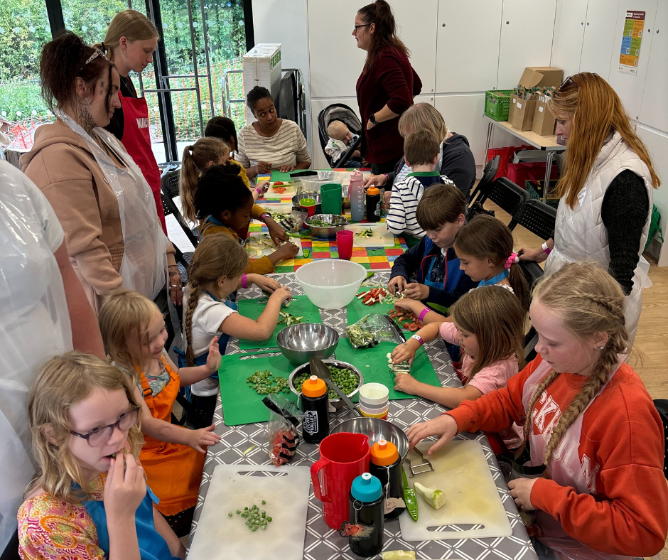 Families preparing meals together during a family cooking workshop.