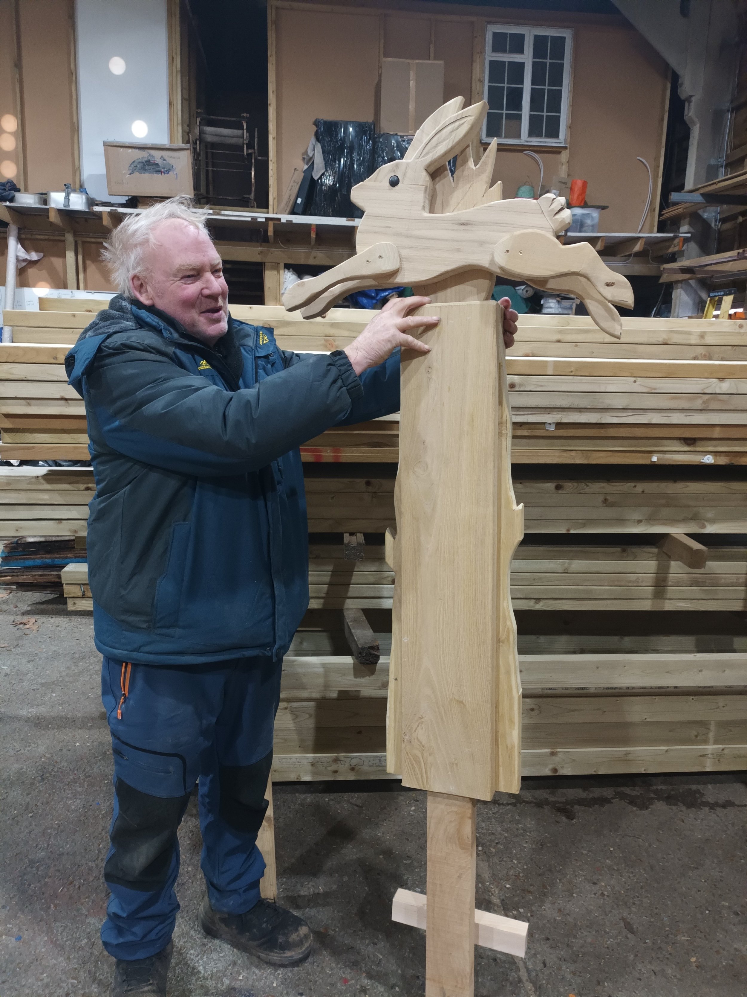 Andy holding a wooden post with a rabbit on top