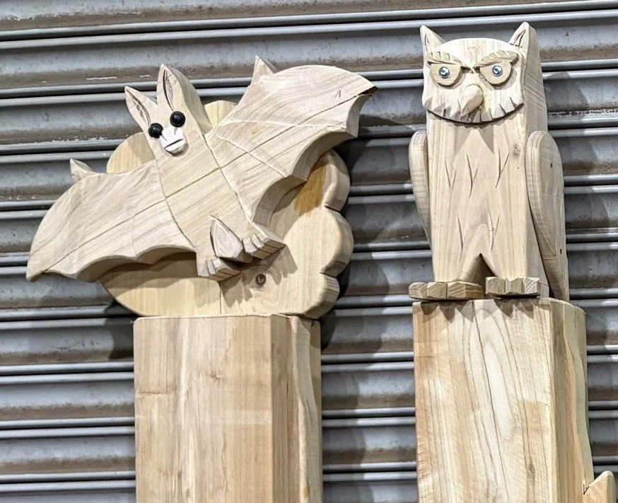Wooden posts topped with a bat and owl