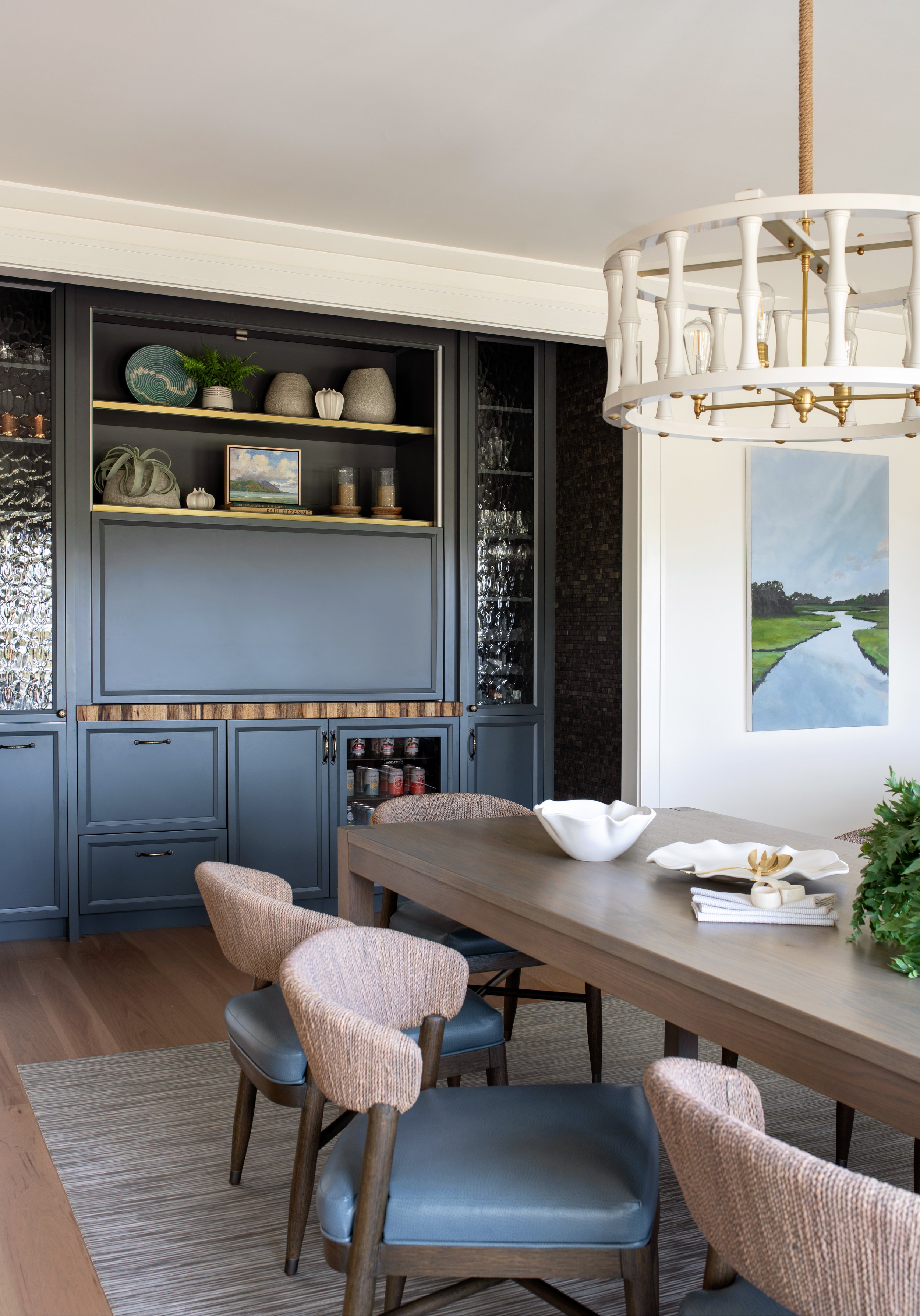 A rustic convertible bar that goes from day to night, located right off the dining space in a coastal home.