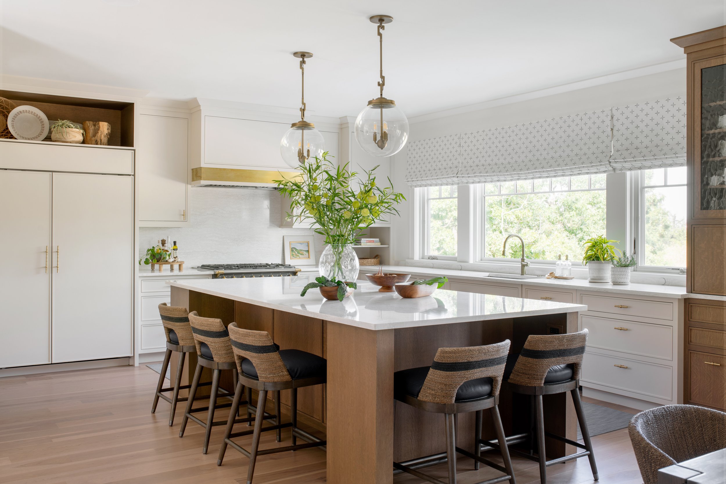 Coastal kitchen with textured, easy clean counters tools, large pendants, and a big kitchen island. Outside mount roman shades.