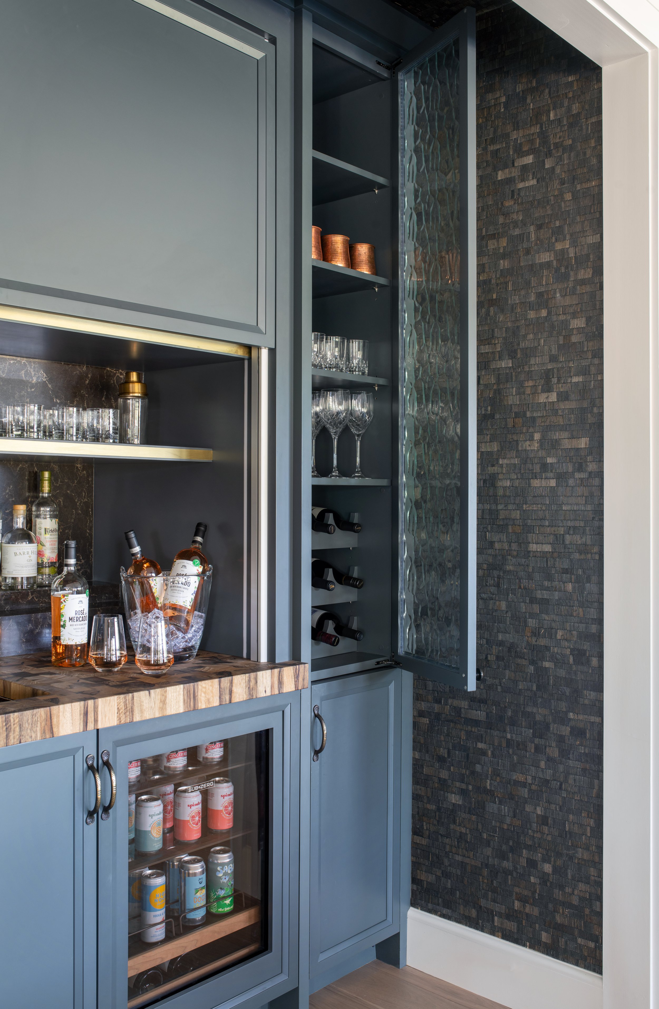Convertible bar with architectural glass accents, rustic wood, and navy details. Coastal kitchen with a rustic bar.