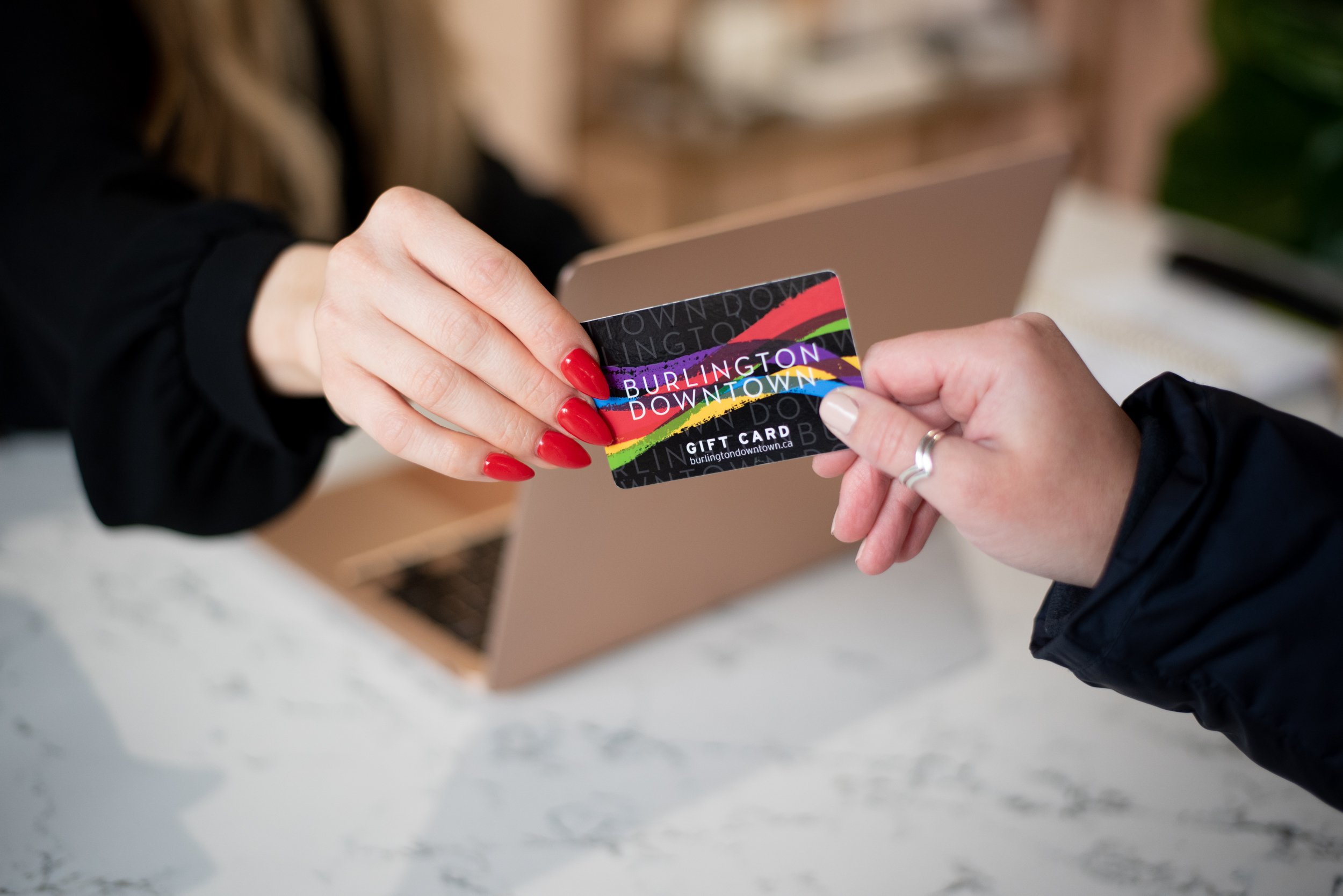  Commercial image of hands paying with a gift card. 