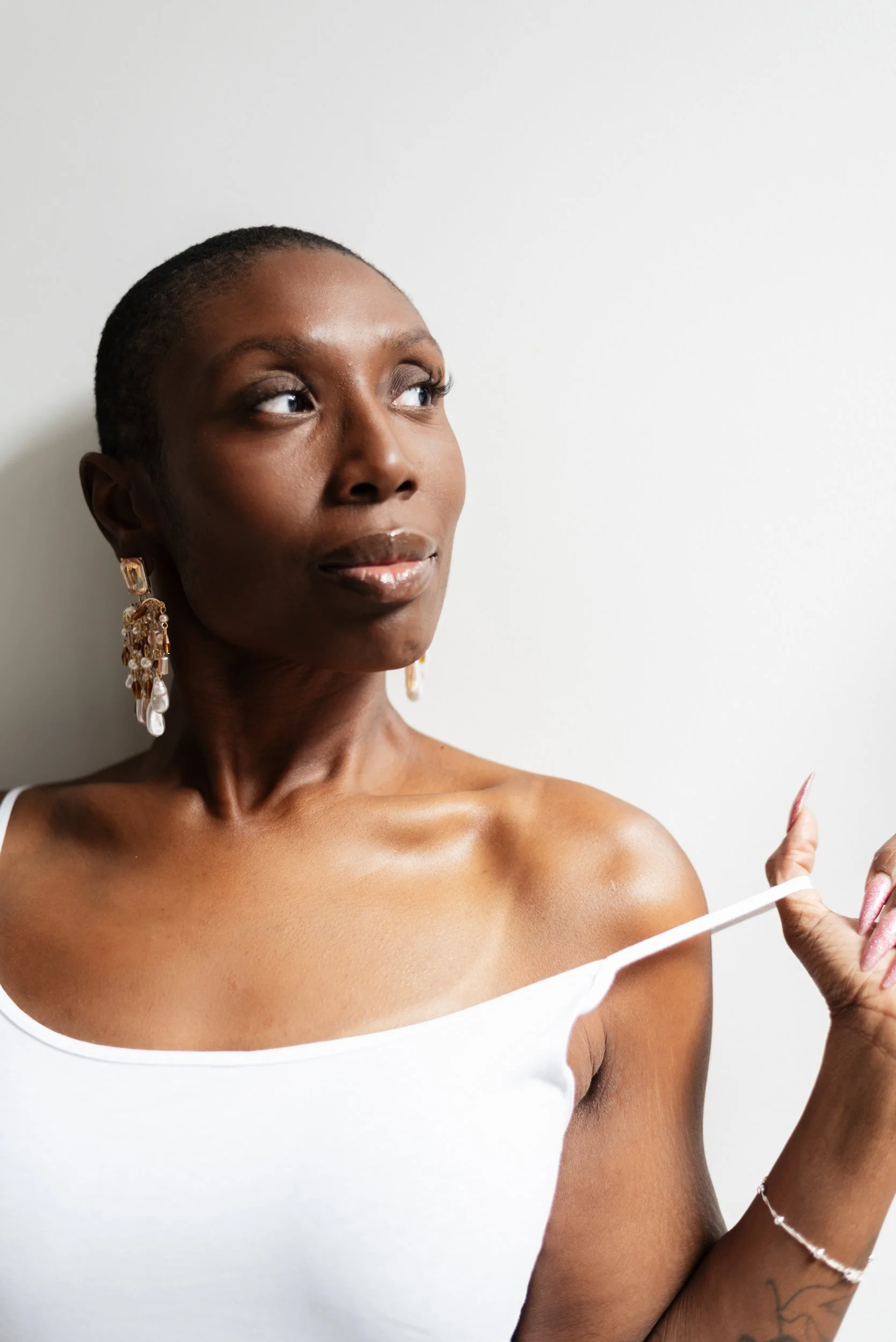 Woman looking into the distance with a tan line on her shoulder.