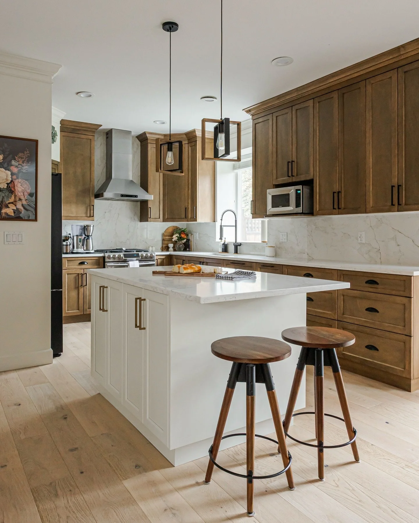 Swipe to see the before! Goodbye 2000&rsquo;s oak and chunky millwork details. Hello gorgeous, custom walnut kitchen. Keeping the warm, beautiful tones of wood as requested by my client &mdash; this kitchen delivers. 
Quartz stone backsplash outfitte