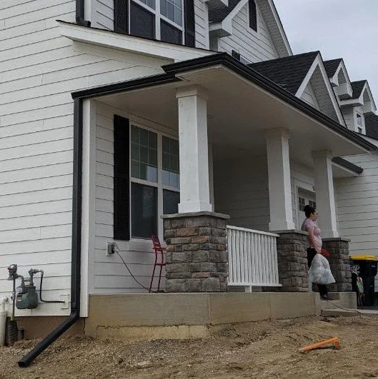 Gutter wrapped around the end of the porch to prevent a downspout from coming down a porch post