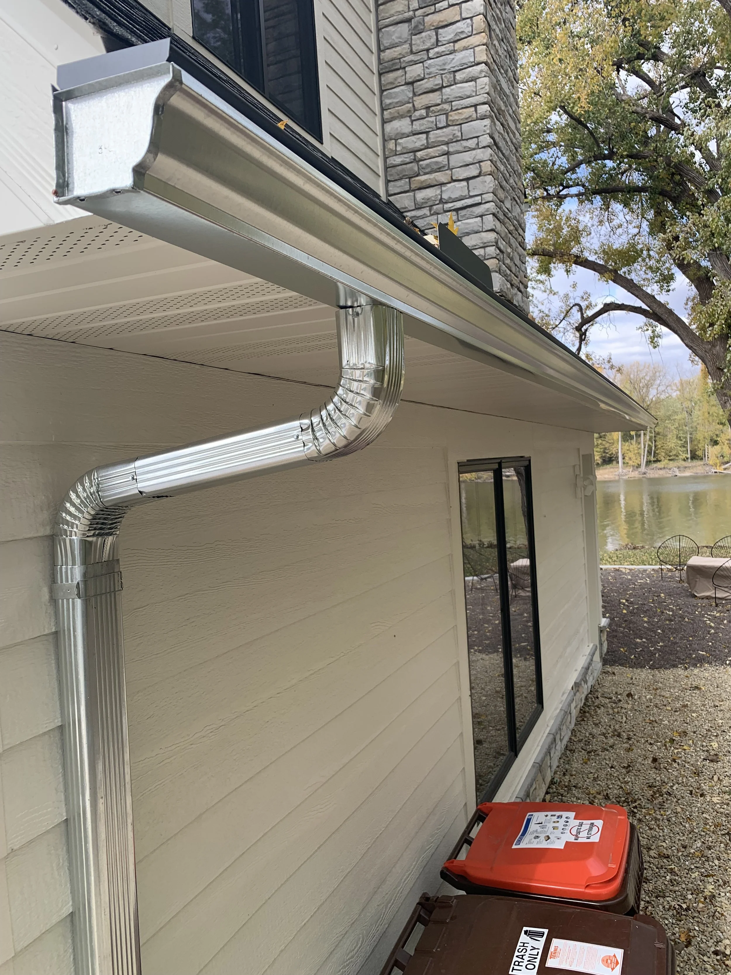 FoxGuard Gutter Covers on a galvanized gutter with a galvanized downspout