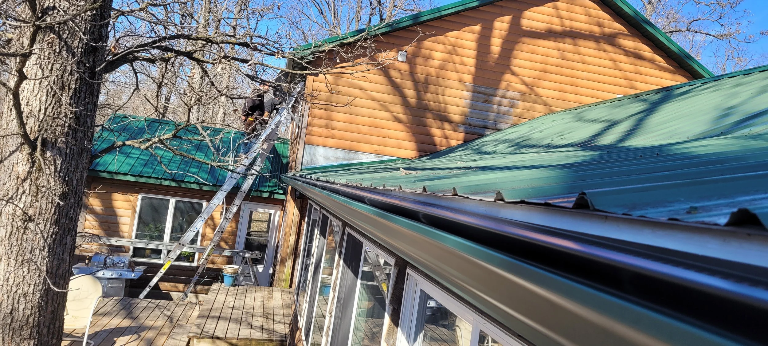 Black high flow gutter cover on a house with green metal roof