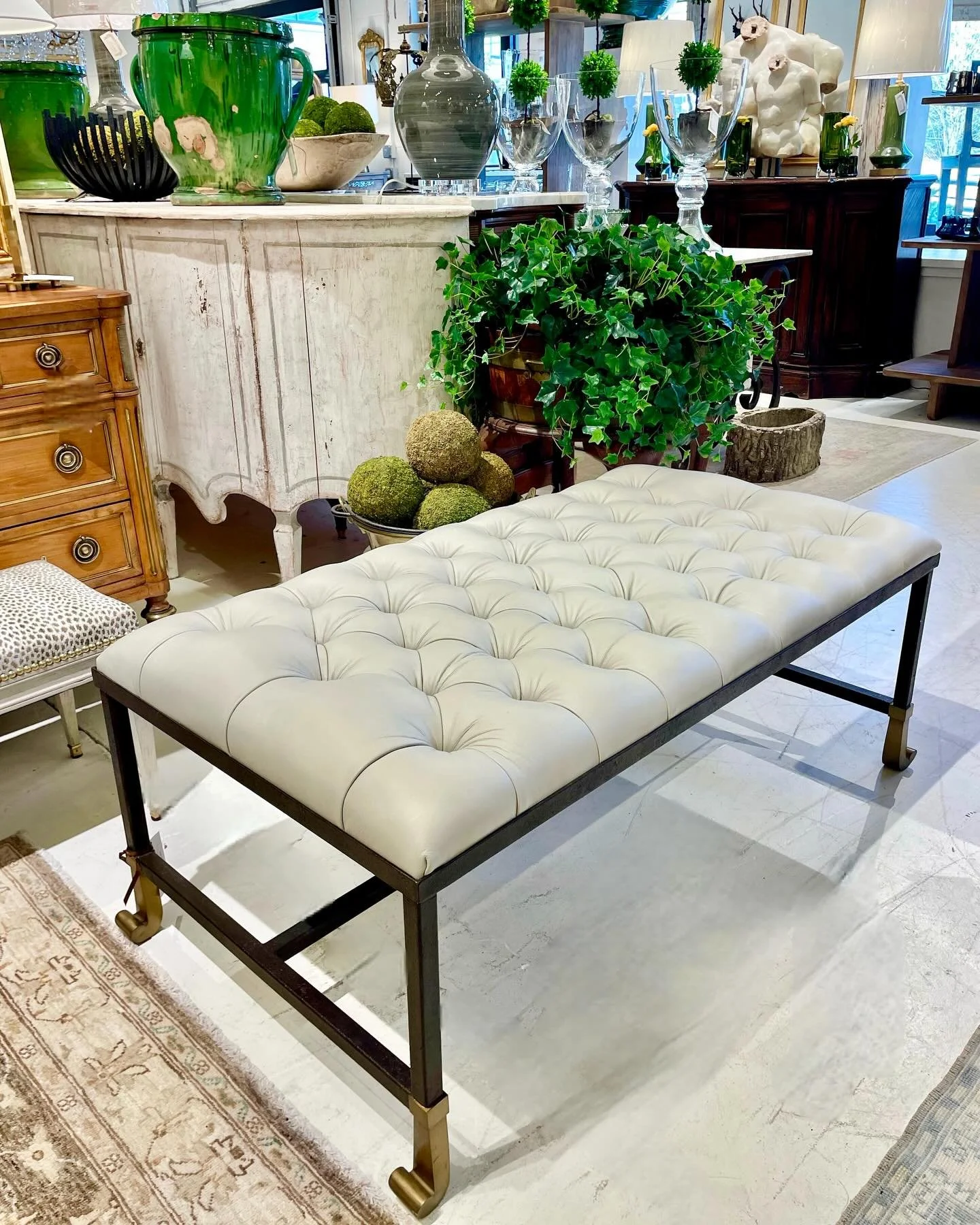 Just in&mdash;A beautiful new tufted leather ottoman. We love the mix of leather and metal&mdash;a beautiful combination of upholstery and metalwork that features antique brass nails at the center of each tuft. The black iron base rests on brushed br