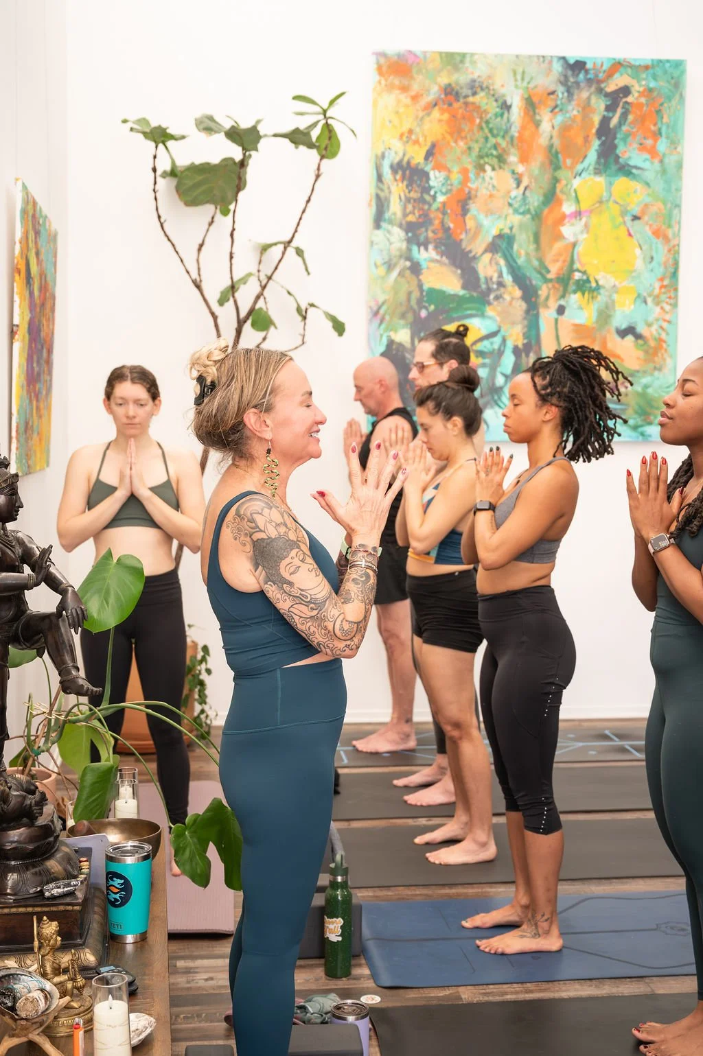 Shelley Carroll leading yoga teacher training trainees in prayer pose at Dancing Dogs Yoga in Atlanta