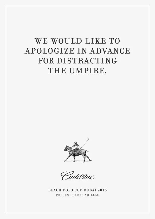 A notice with the text 'We would like to apologize in advance for distracting the umpire.' and a logo for Cadillac featuring a polo player on a horse, promoting the Cadillac Beach Polo Cup Dubai 2015.