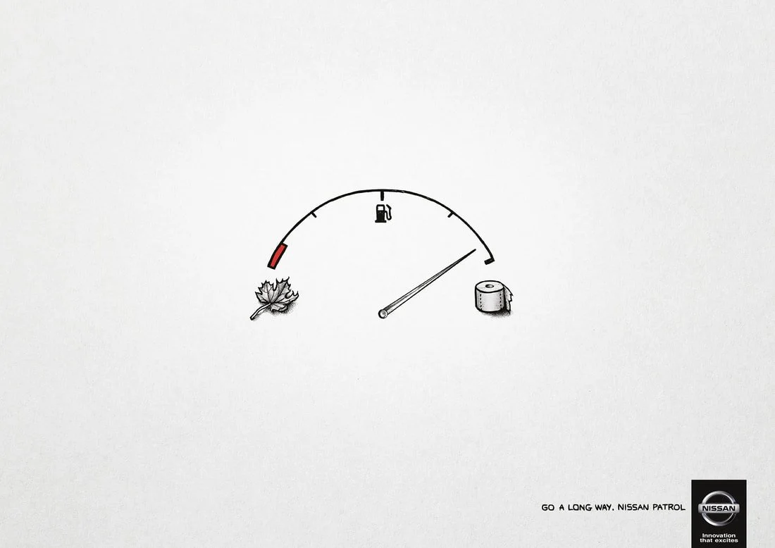 Fuel gauge showing low fuel, with an illustration of a leaf and a roll of toilet paper underneath. Nissan logo and slogan 'Go a long way. Nissan Patrol' in the corner.