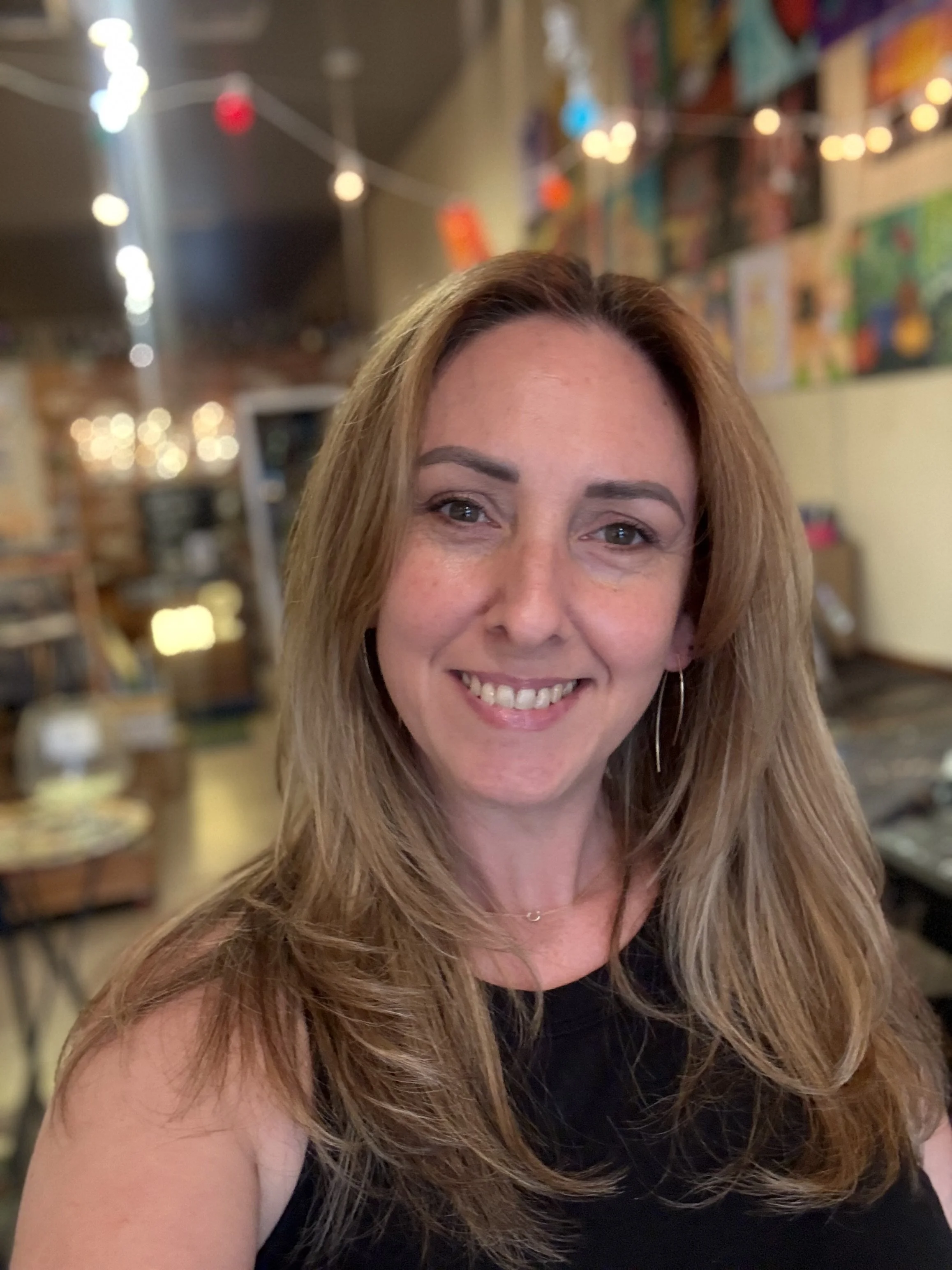 a headshot of a smiling woman with long blond hair and light skin