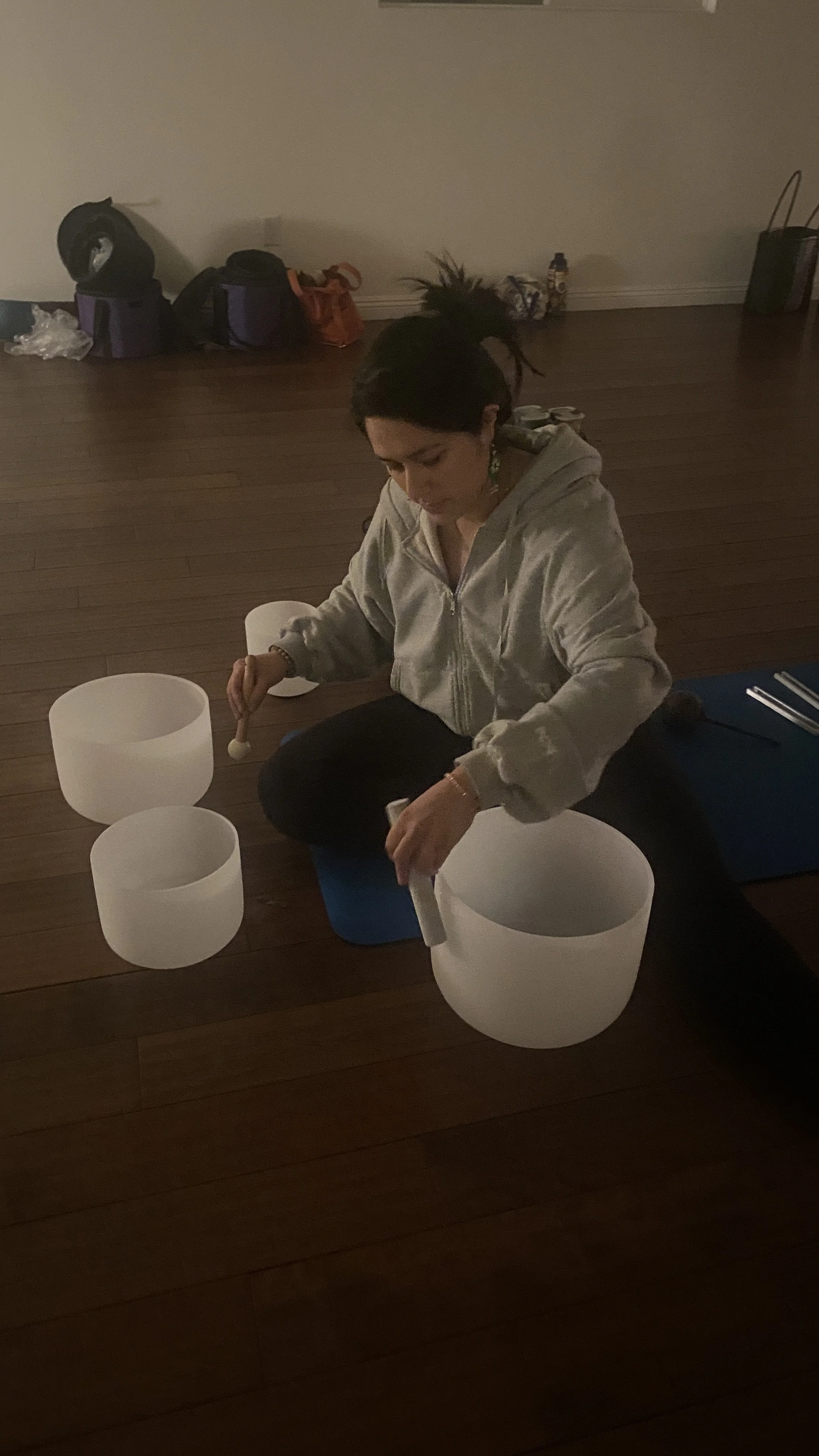 Student sound healer practicing with crystal singing bowls
