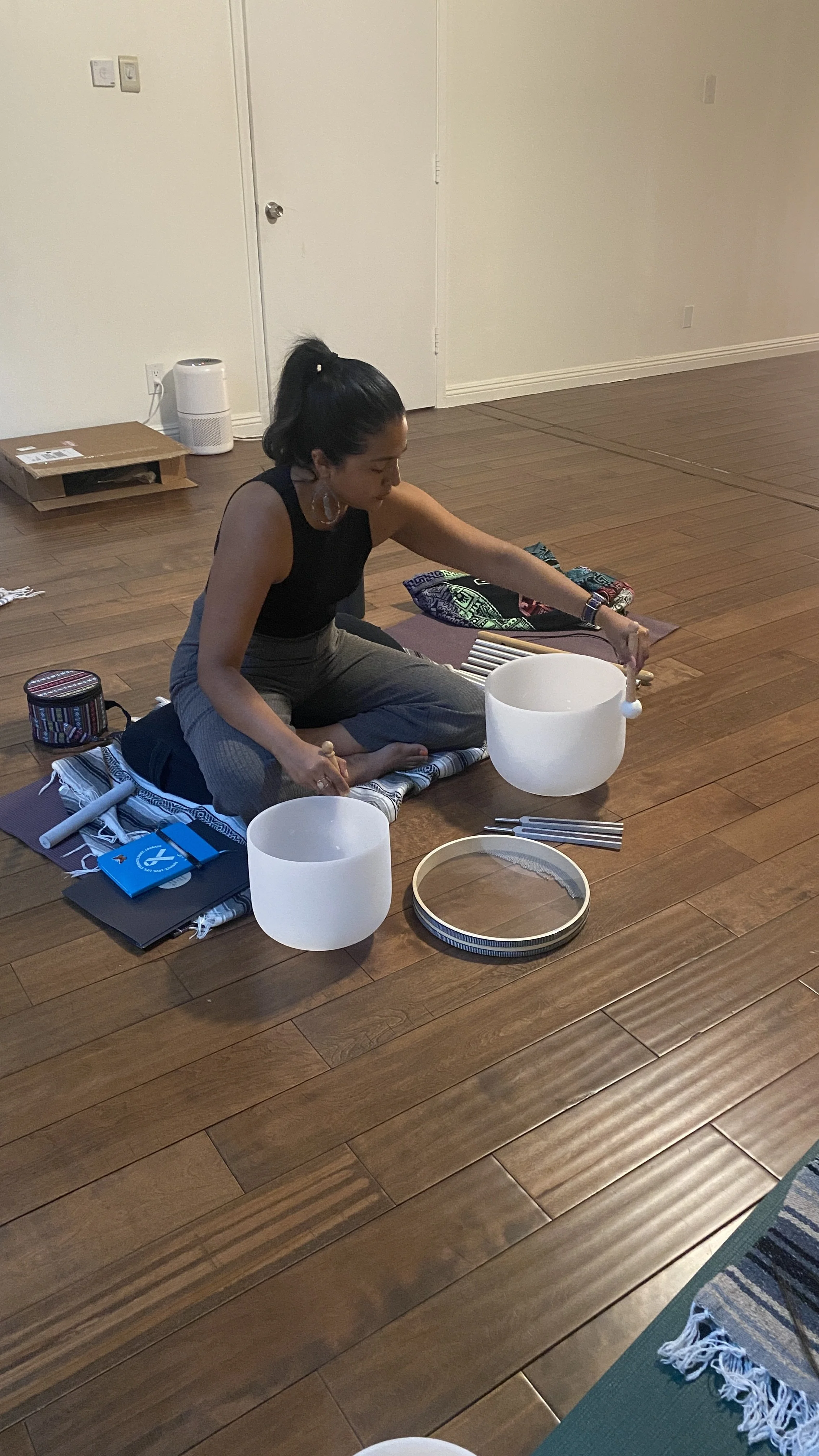 Student sound healer practicing with crystal singing bowls
