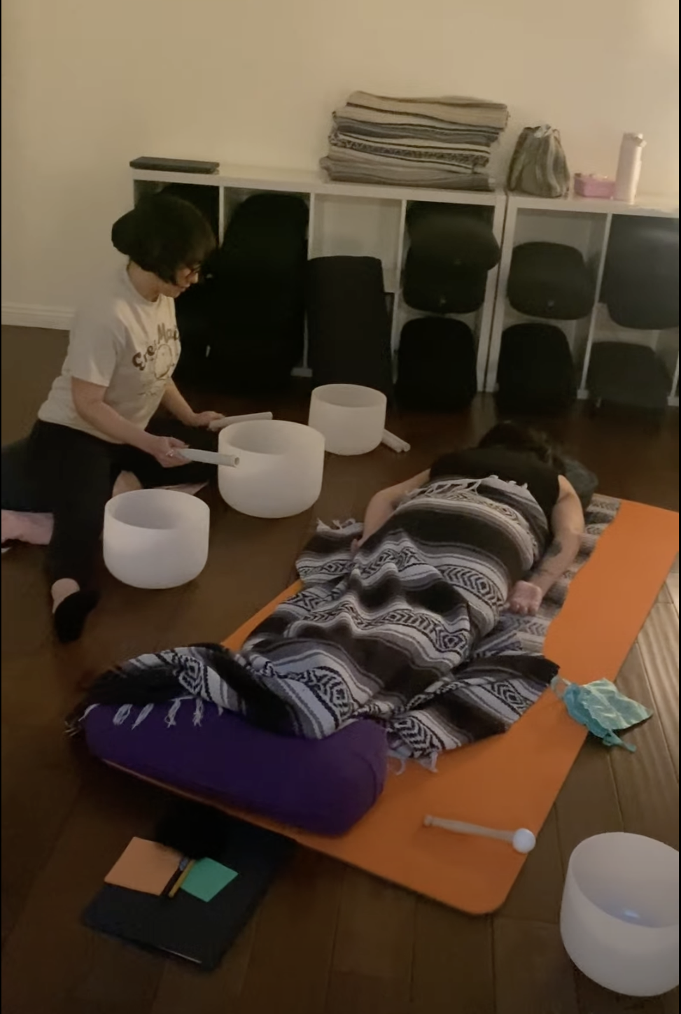 Student playing crystal singing bowls for another student