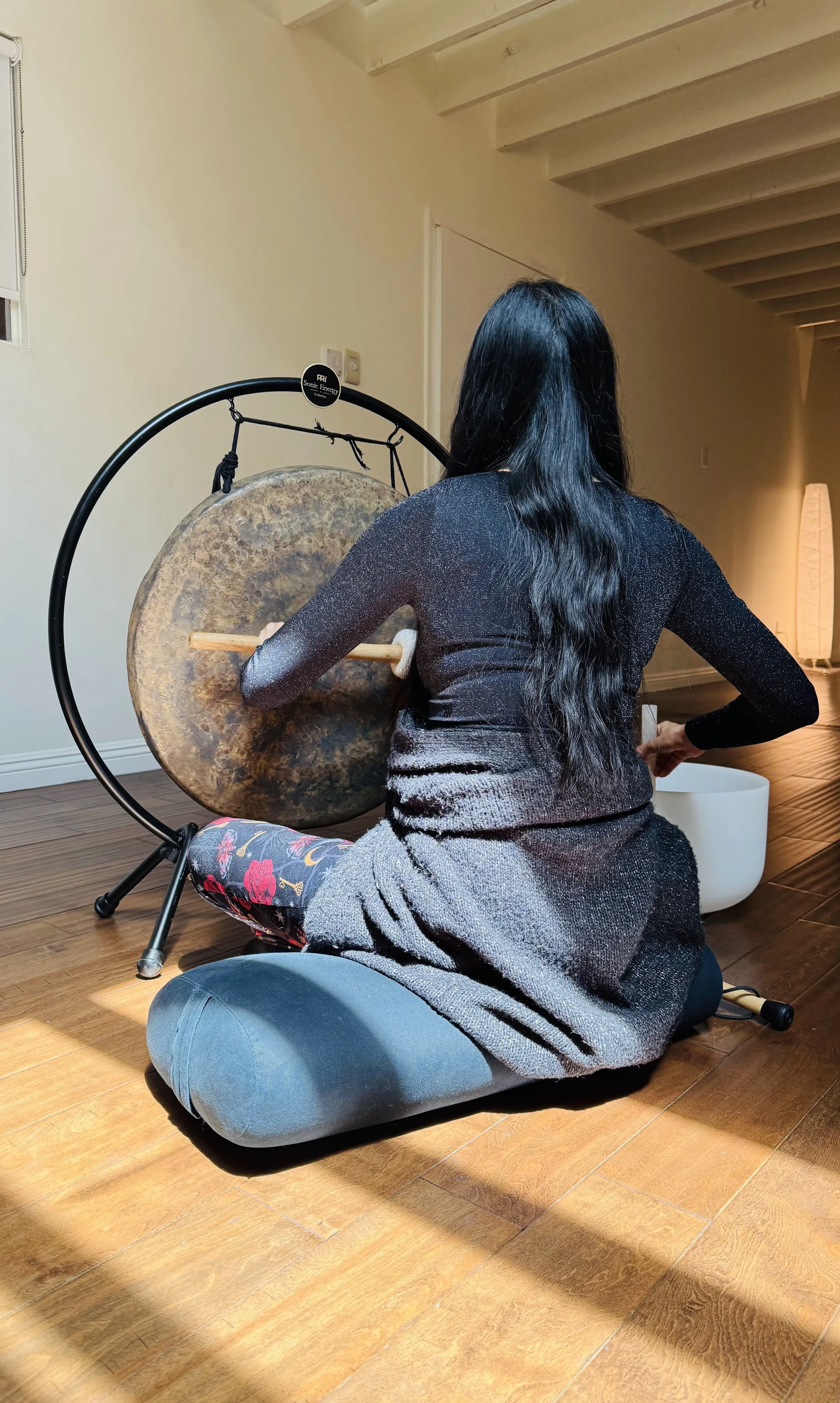 Student sound healer practicing with gong