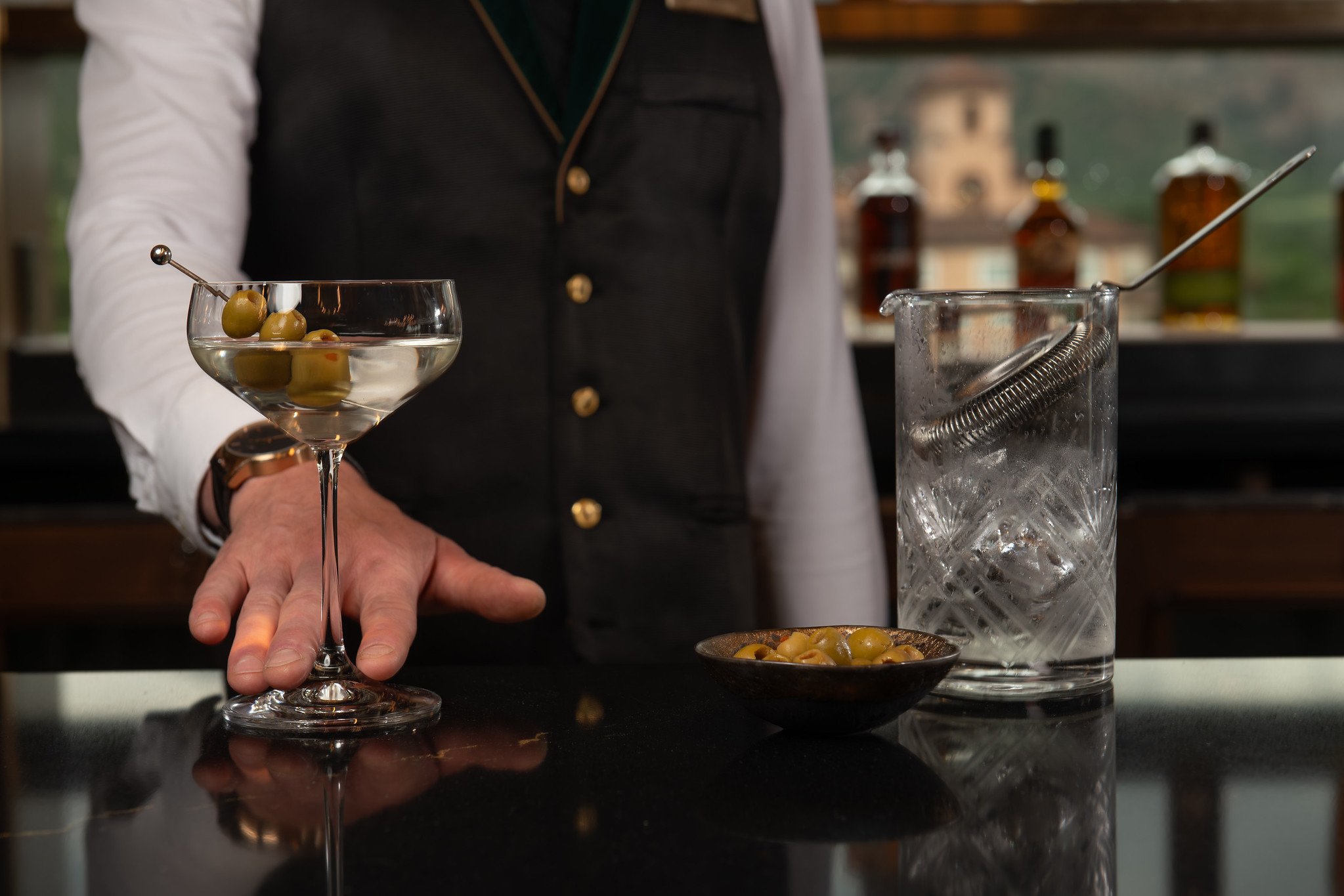 Bartender serving a handcrafted martini in an upscale hotel bar, highlighting luxury hospitality, premium service, and elevated guest experience.