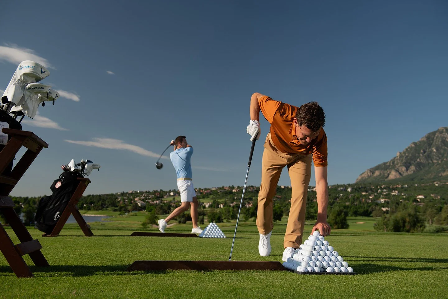 Luxury hospitality photography featuring two men golfing at a high-end resort with mountain views, captured by Chad Chisholm Creative.