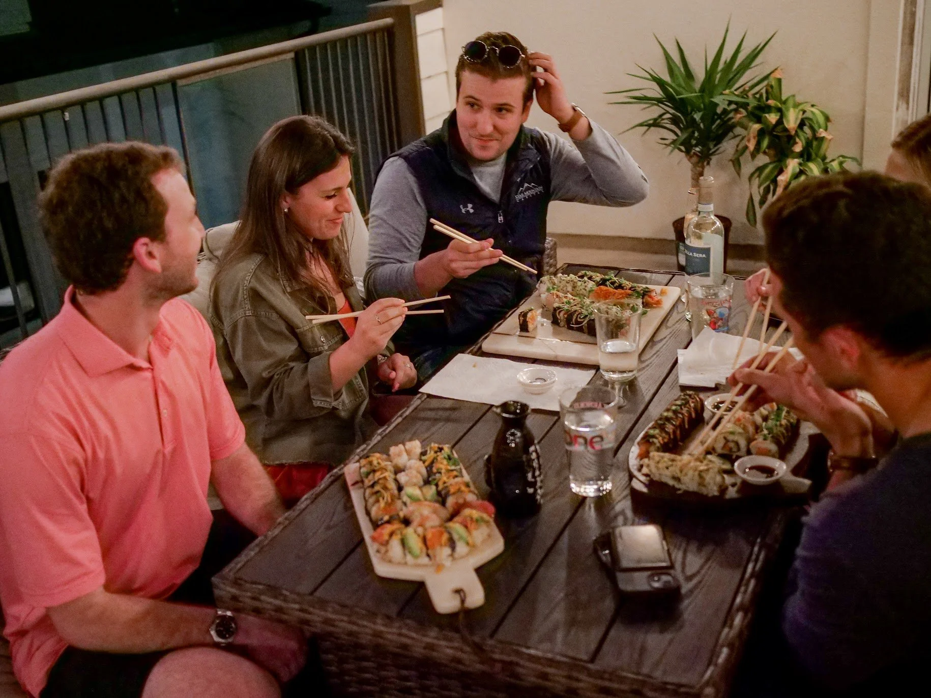 Friends enjoying homemade sushi rolls together around a dinner table