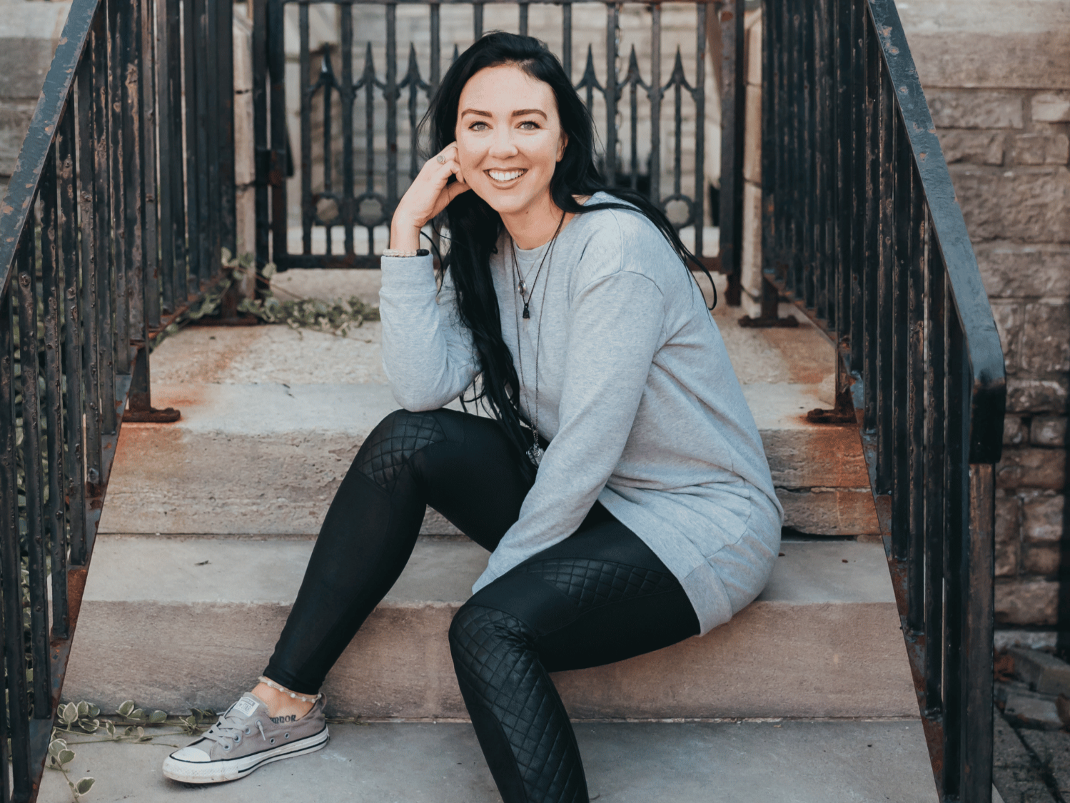 Chivonne Monaghan sitting on stone steps, approachable and supportive grief and resilience mentor.