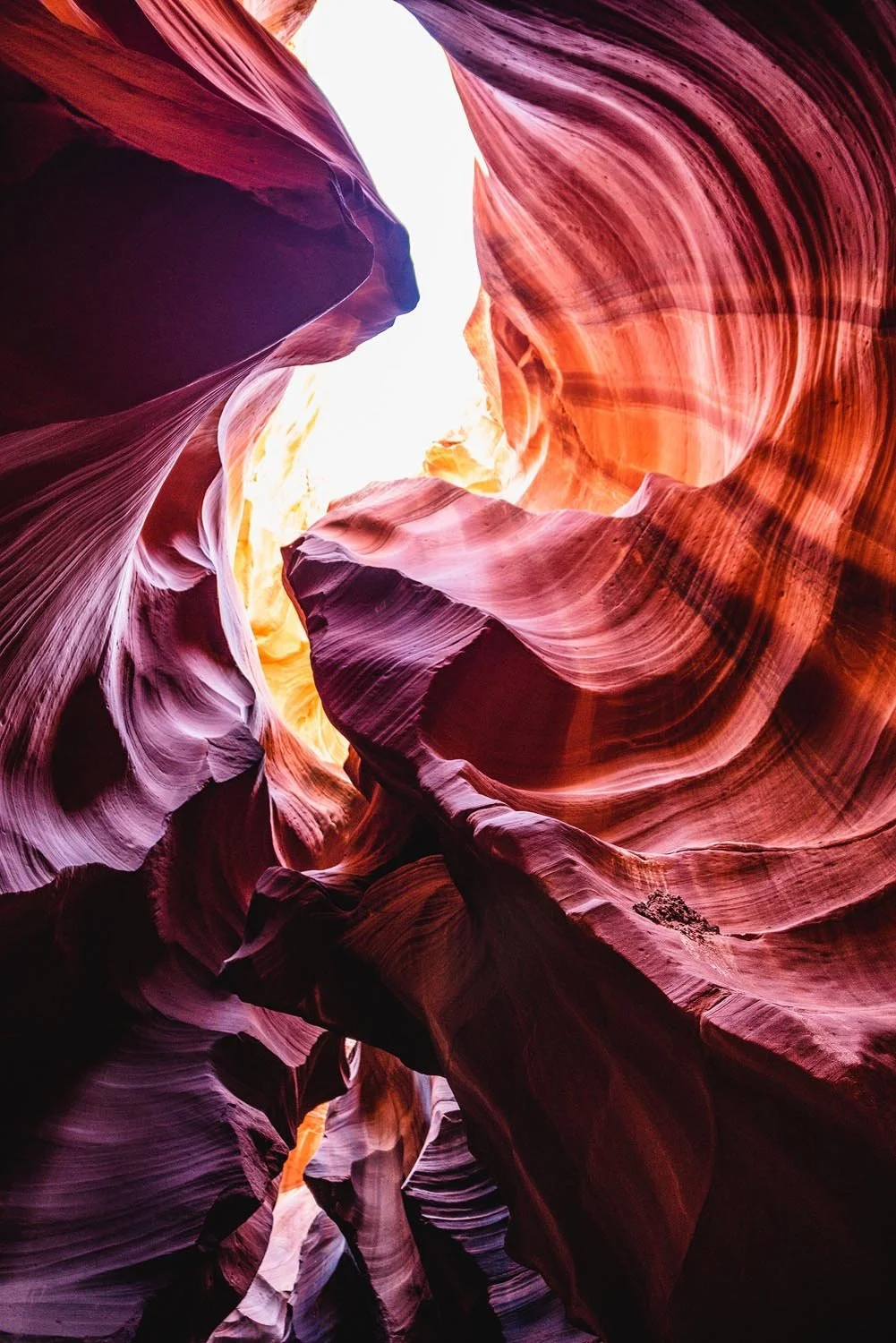 Antelope Canyon with swirling red sandstone formations and sunlight.