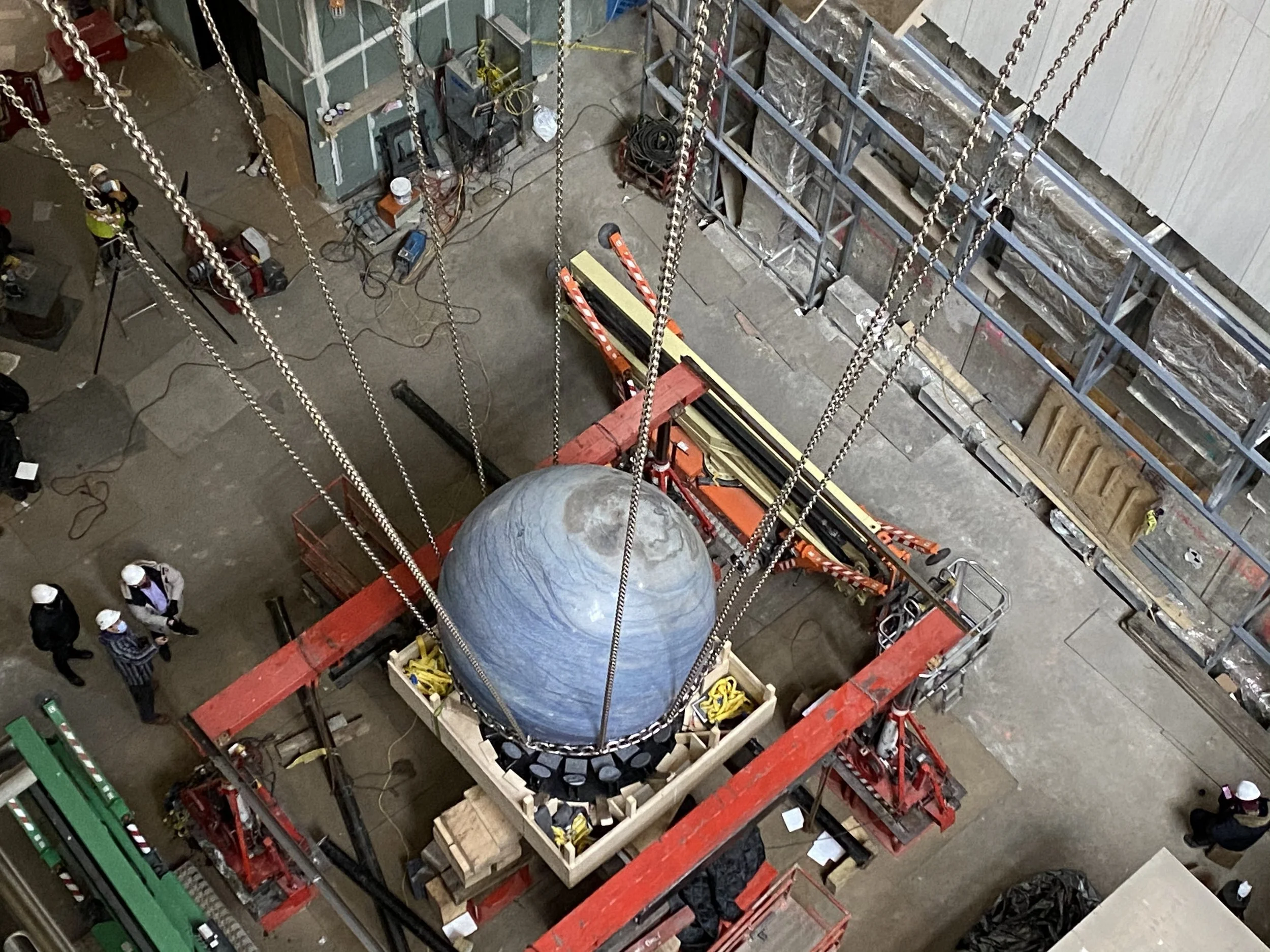 Boom lifts and steel chains fill the 550 Madison lobby during the overnight installation of Solid Sky