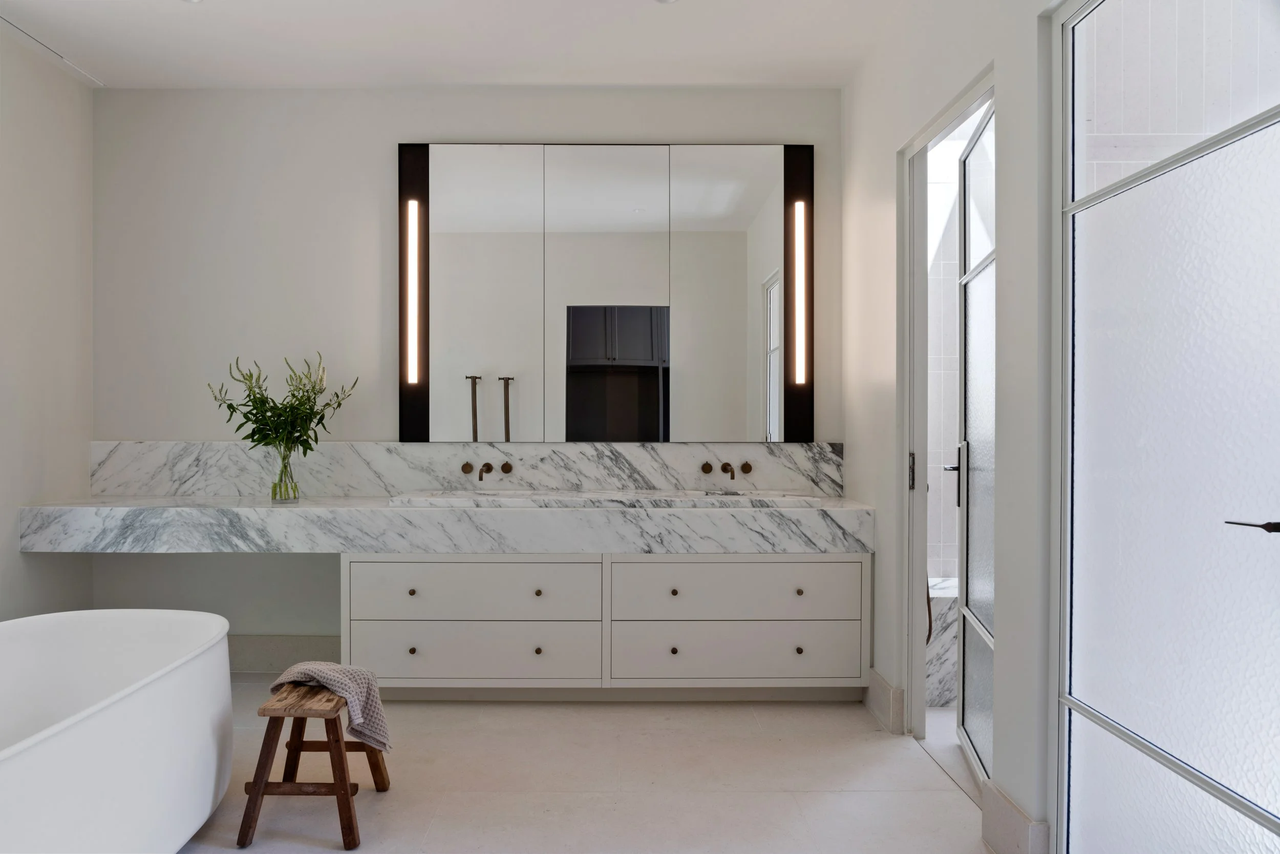 Main bathroom with freestanding bath, marble vanity and soft natural light in a country home