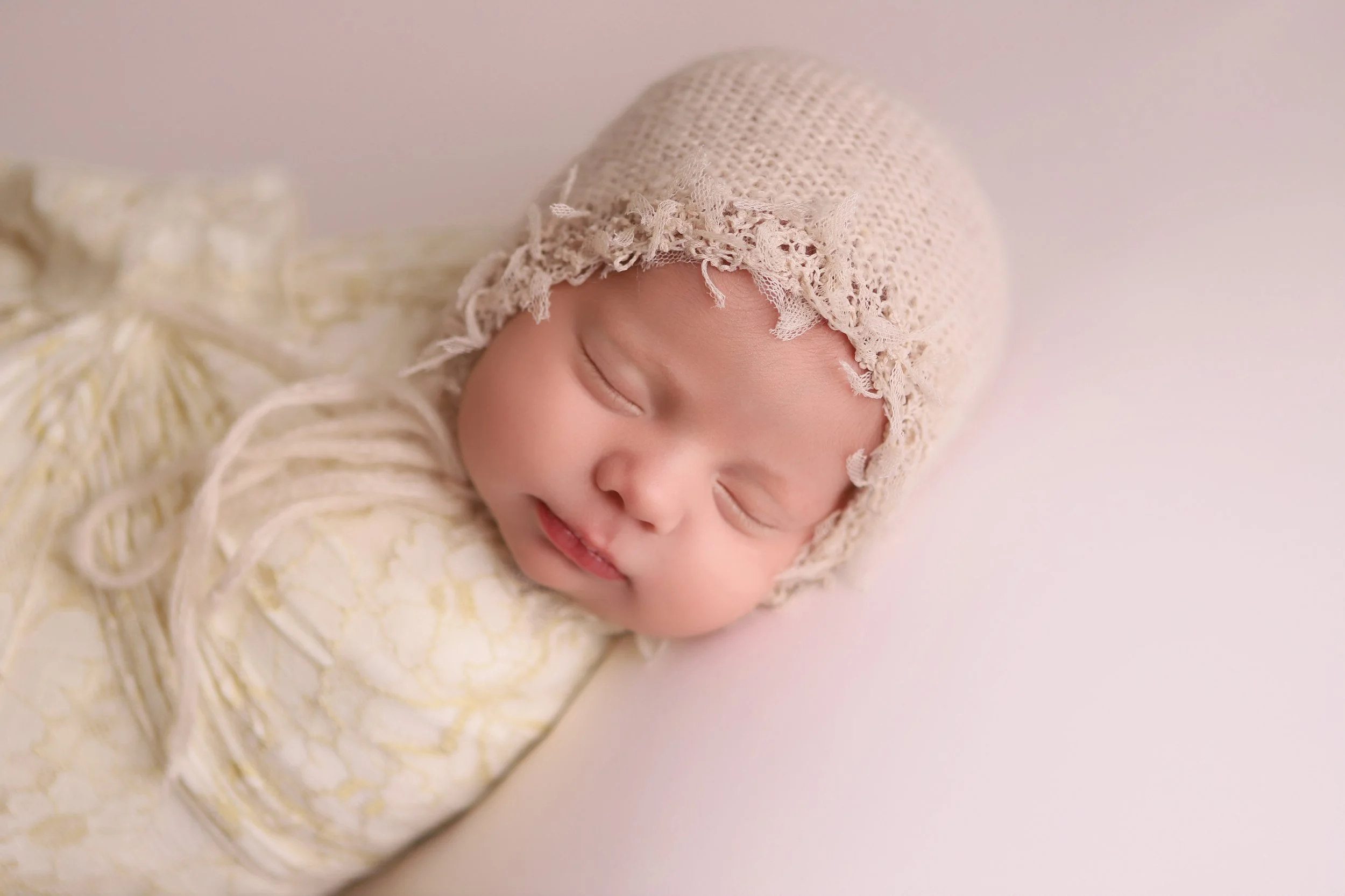 newborn baby girls with cream colored cap