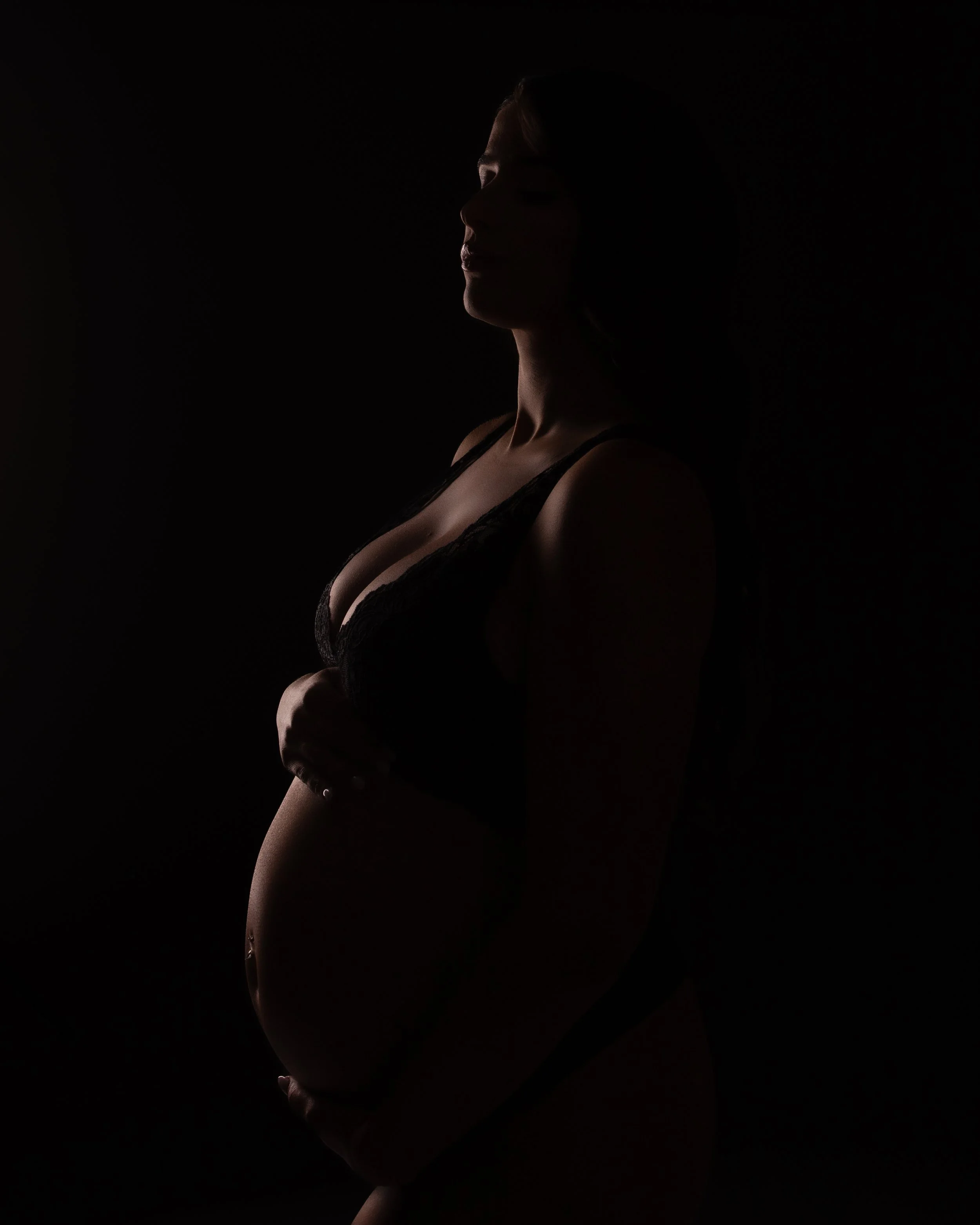 a silhoutte of a pregant woman holding her belly