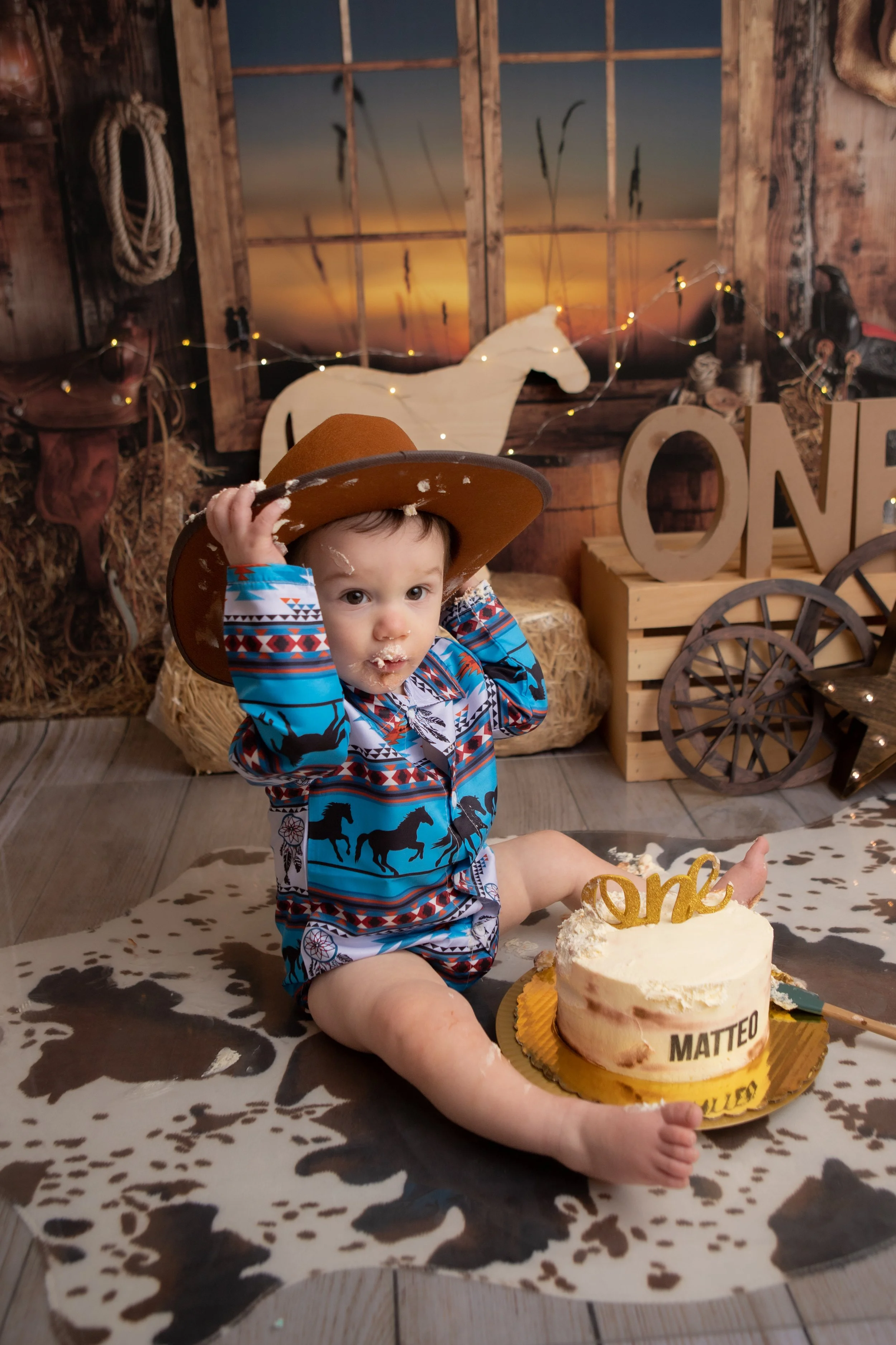 little boy wearing a cowboy hat with a western background