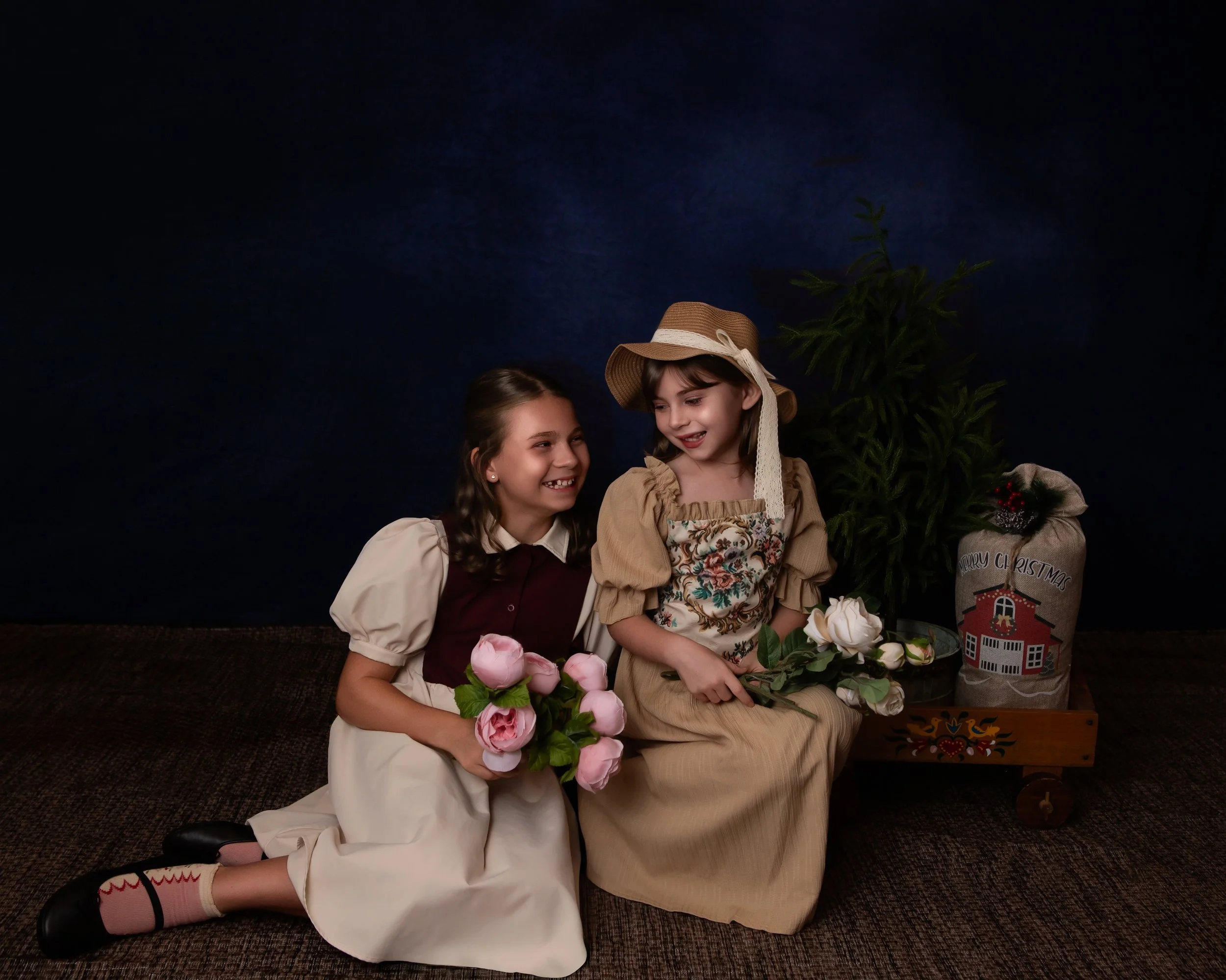 two girls smiling at eachother holding flowers wearing vintage clothing