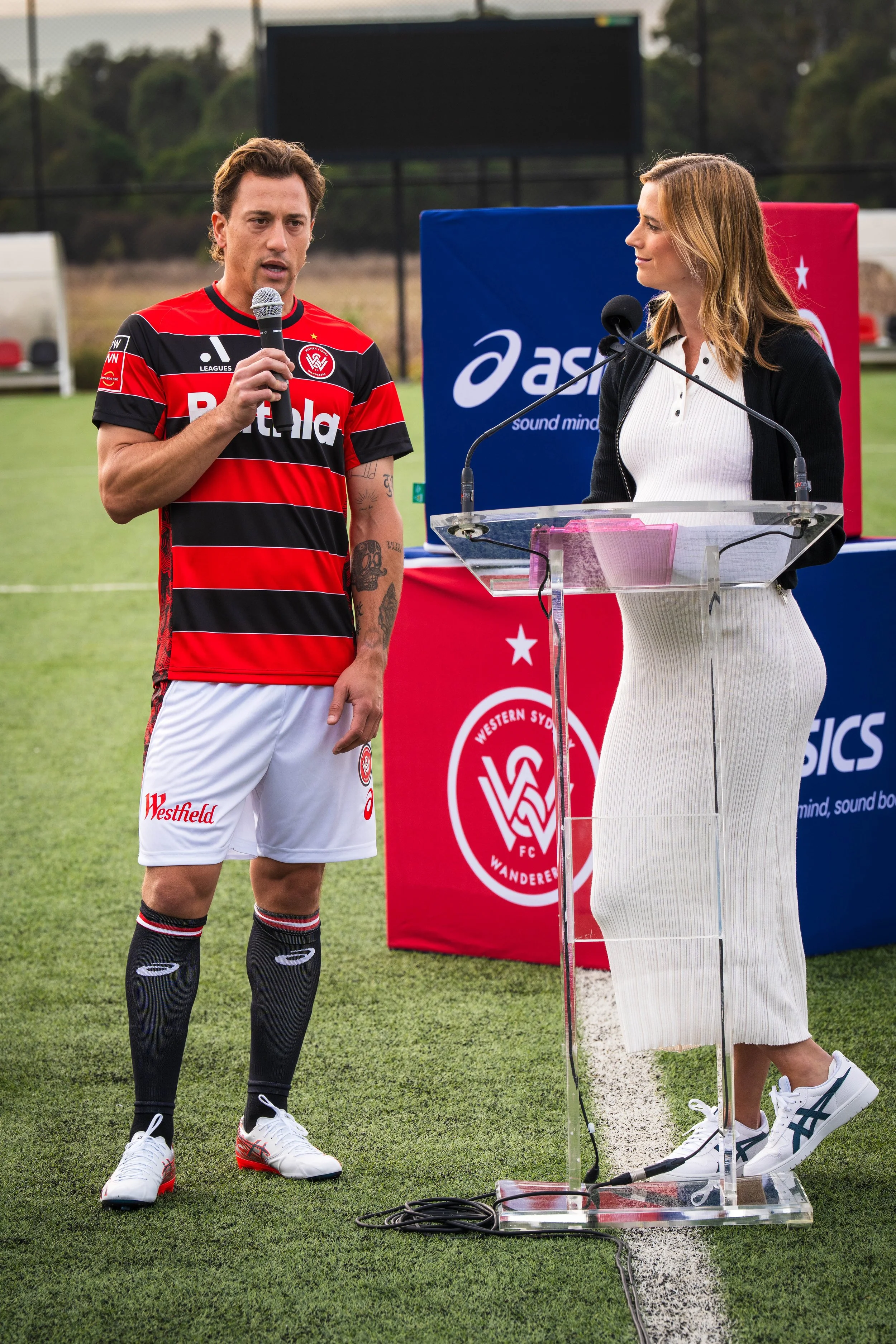 Kate Allman sports presenter, MC and football announcer speaking with Western Sydney Wanderers A-League player