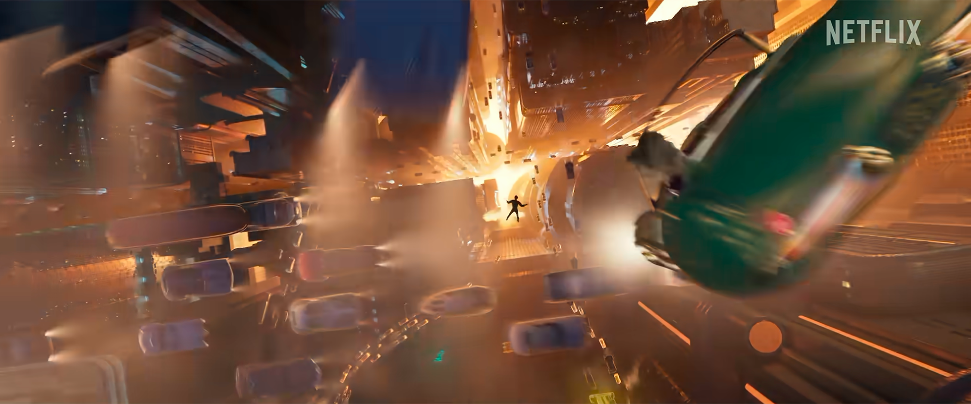 A person falling through the air amid a cityscape at night, with buildings, bright lights, and a flying vehicle nearby, in a scene from an action or sci-fi movie.