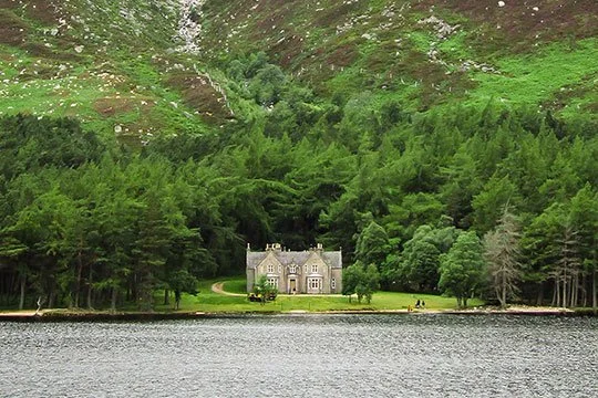Queen Victoria's historic stone lodge on the shores of Loch Muick, surrounded by the dramatic mountains of Royal Deeside.