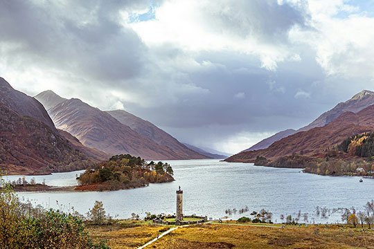A steam train crossing the famous Glenfinnan Viaduct, a dream destination for our custom-planned Scottish road trips.