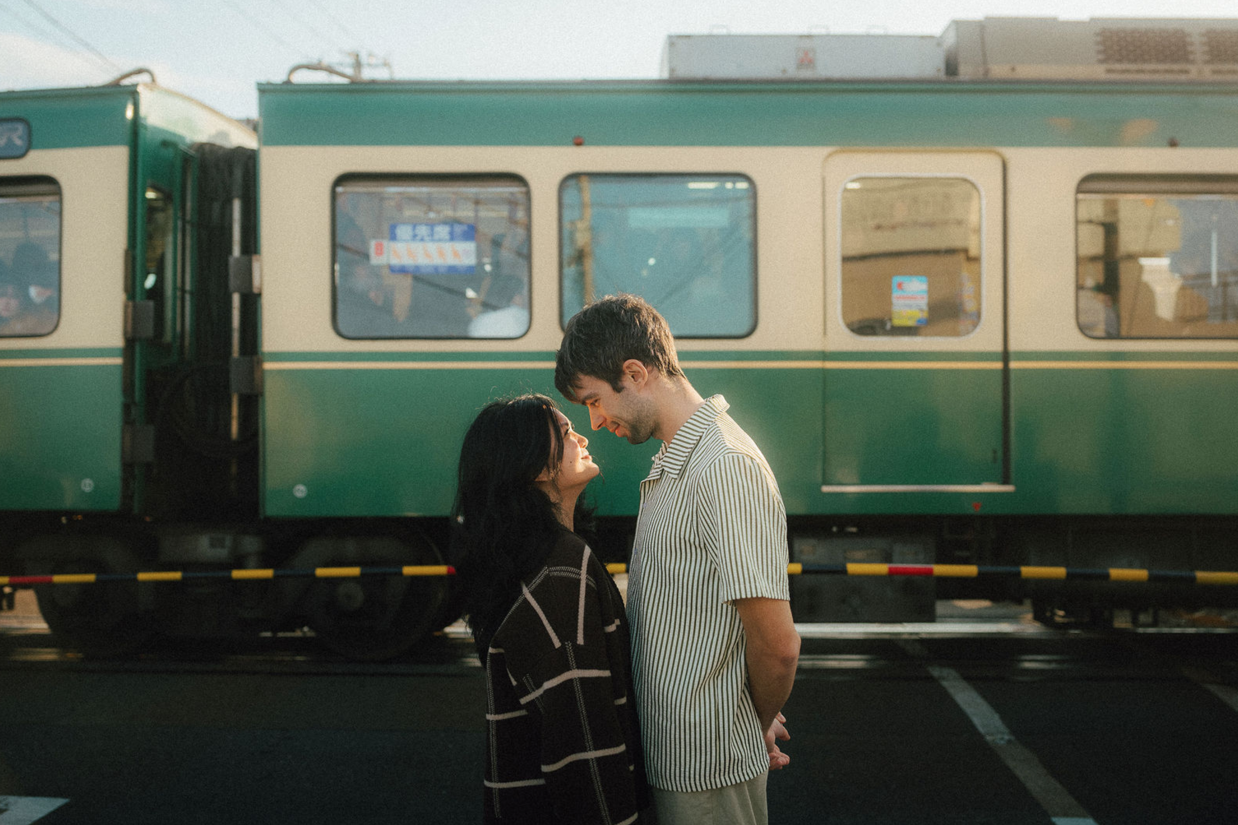 Couple looking at each other in front of Enoden in Kamakura