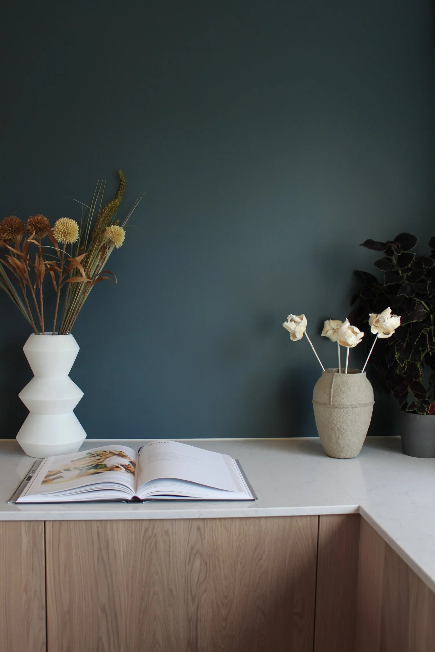 Veggene på kjøkkenet er malt i en dyp blågrønn tone som står fint mot treverket.