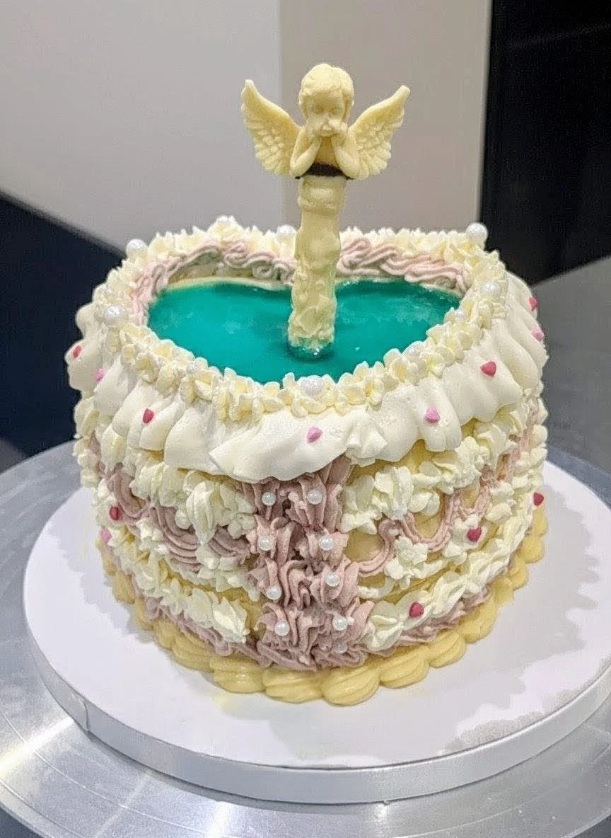 Heart shape fountain cake with chocolate angel and water