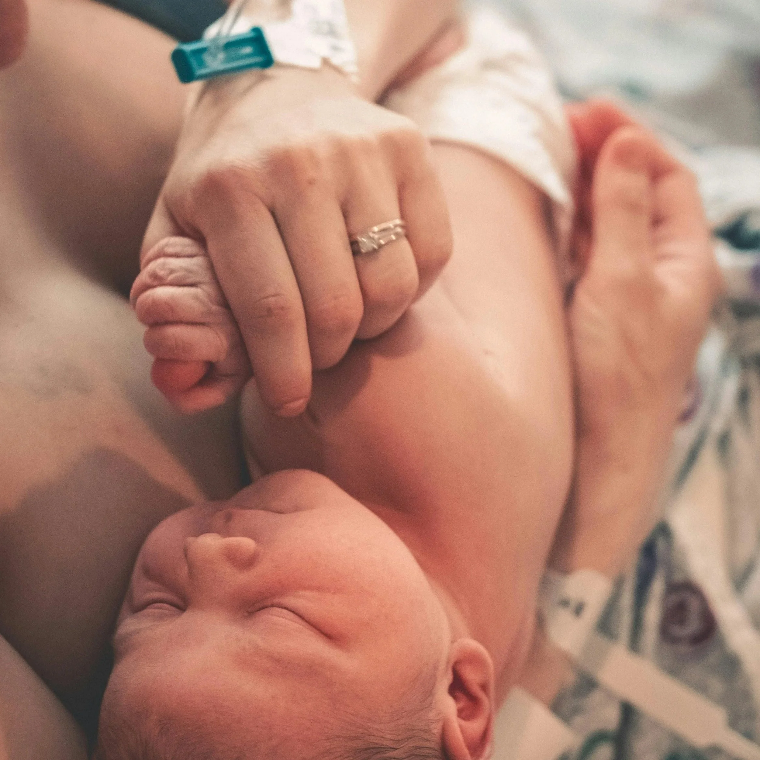 Newborn baby being held by a mother while in hospital after giving birth
