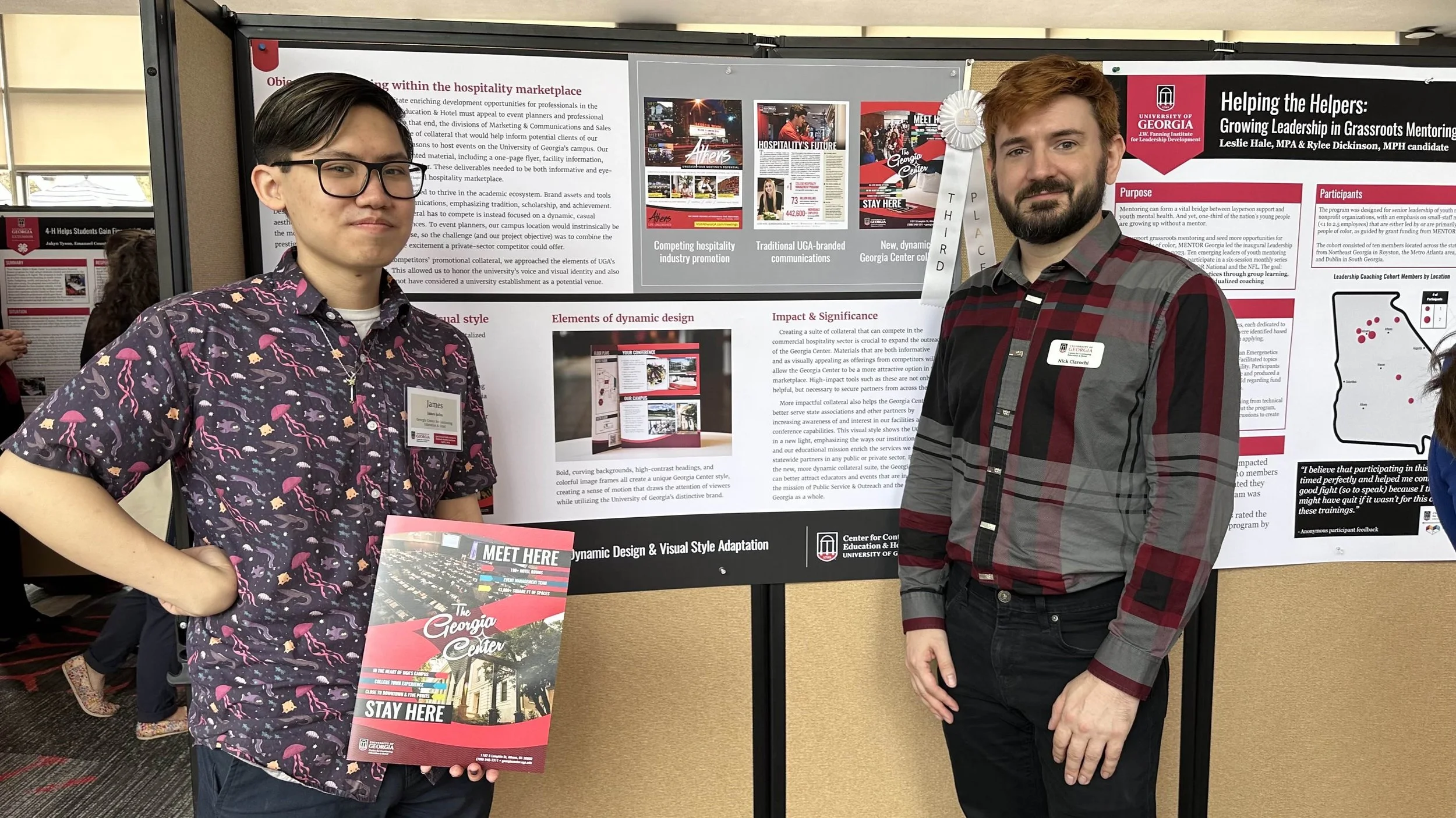 James Jadus and Nick Ciarochi, his supervisor, in front of their academic poster. It has a white ribbon pinned to it that says "Third Place."