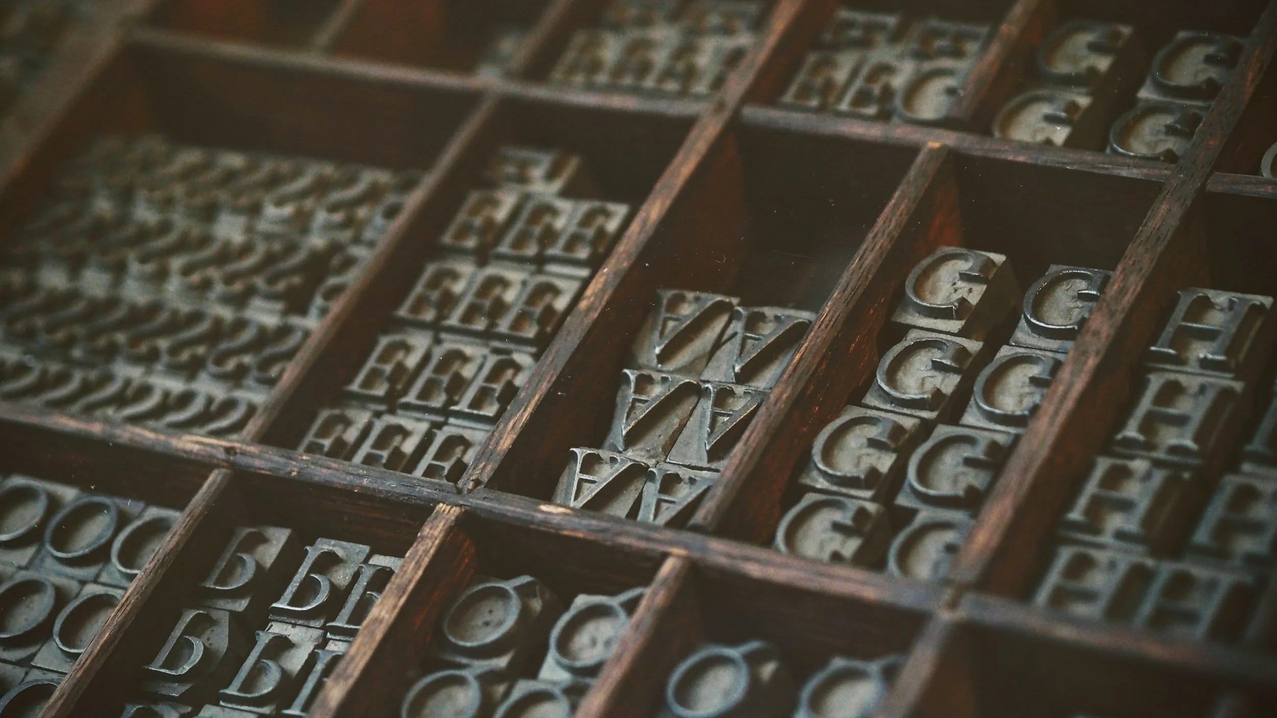 Vintage alphabet letterpress type arranged in wooden compartments.