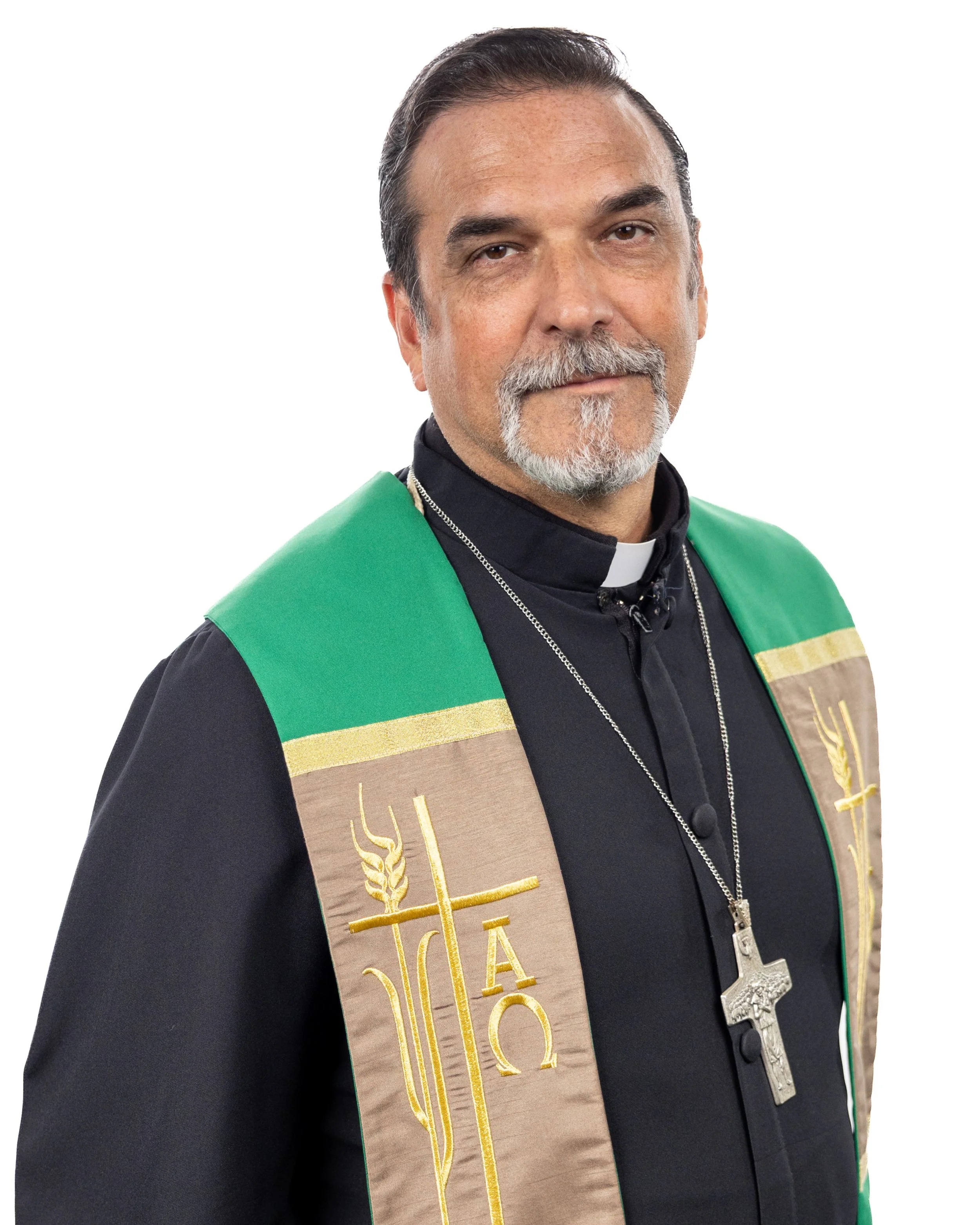 Man in clergy attire with a gray blazer smiling against a white background.