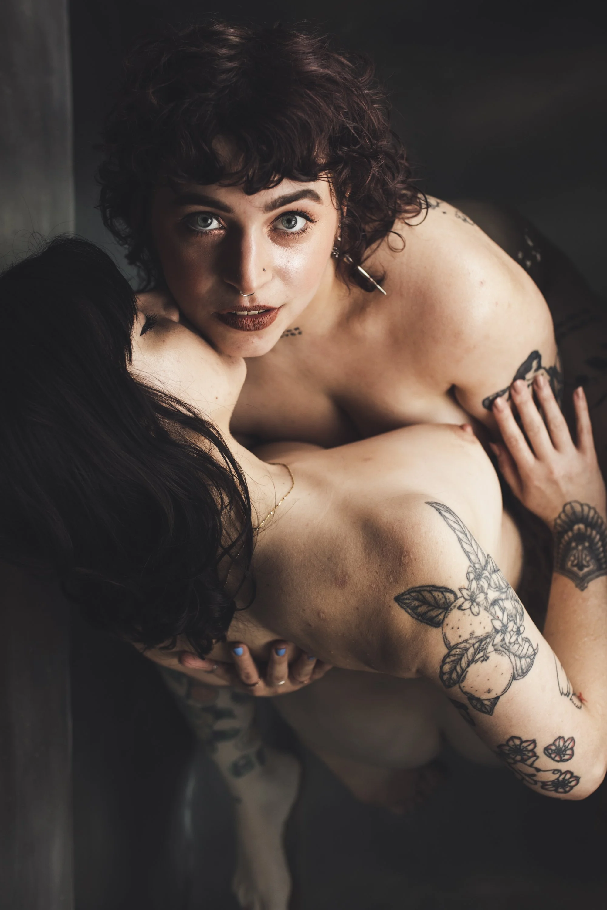 two nude white women kissing and embracing