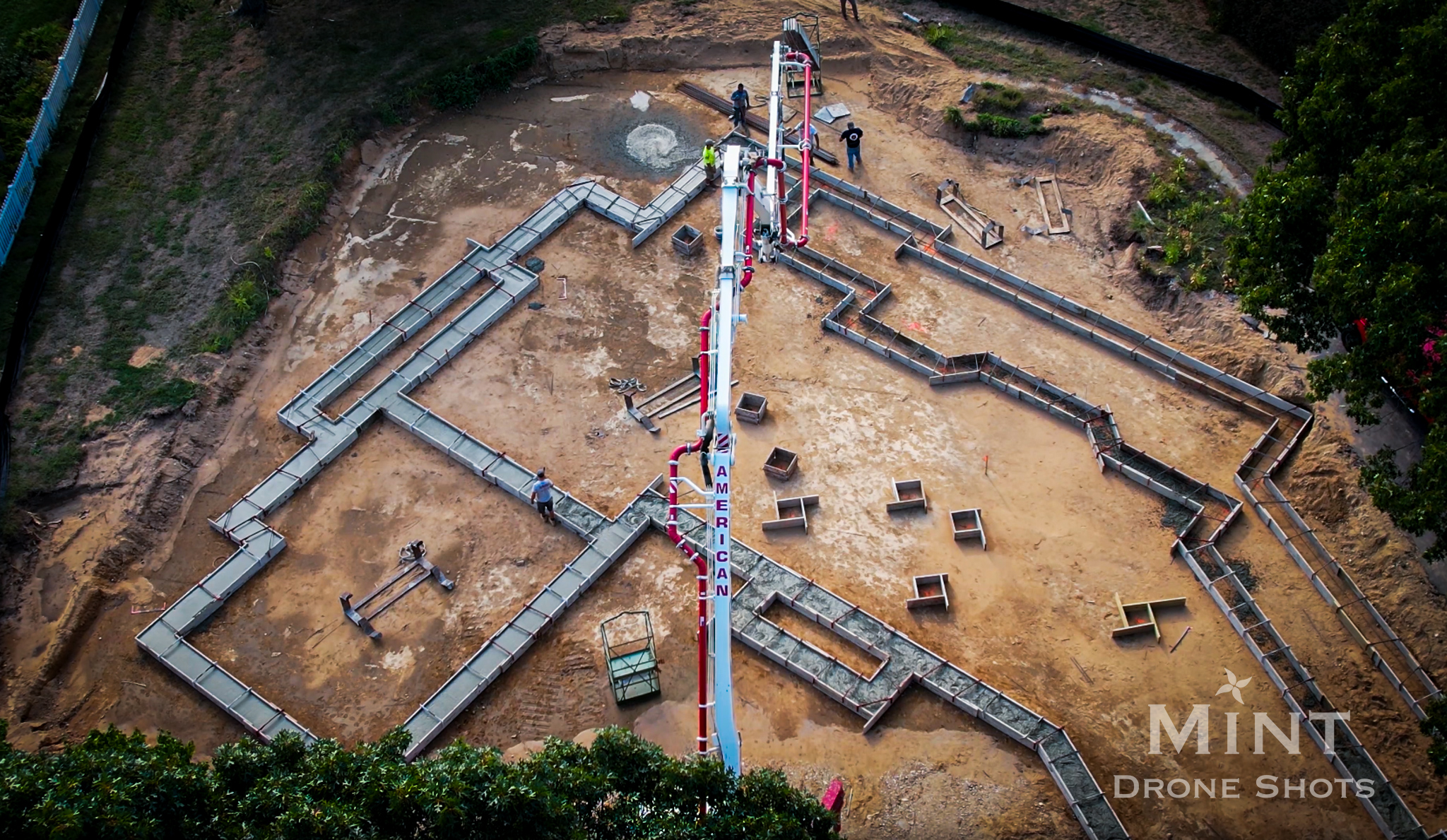 Aerial view of a construction site with foundation layout and equipment.