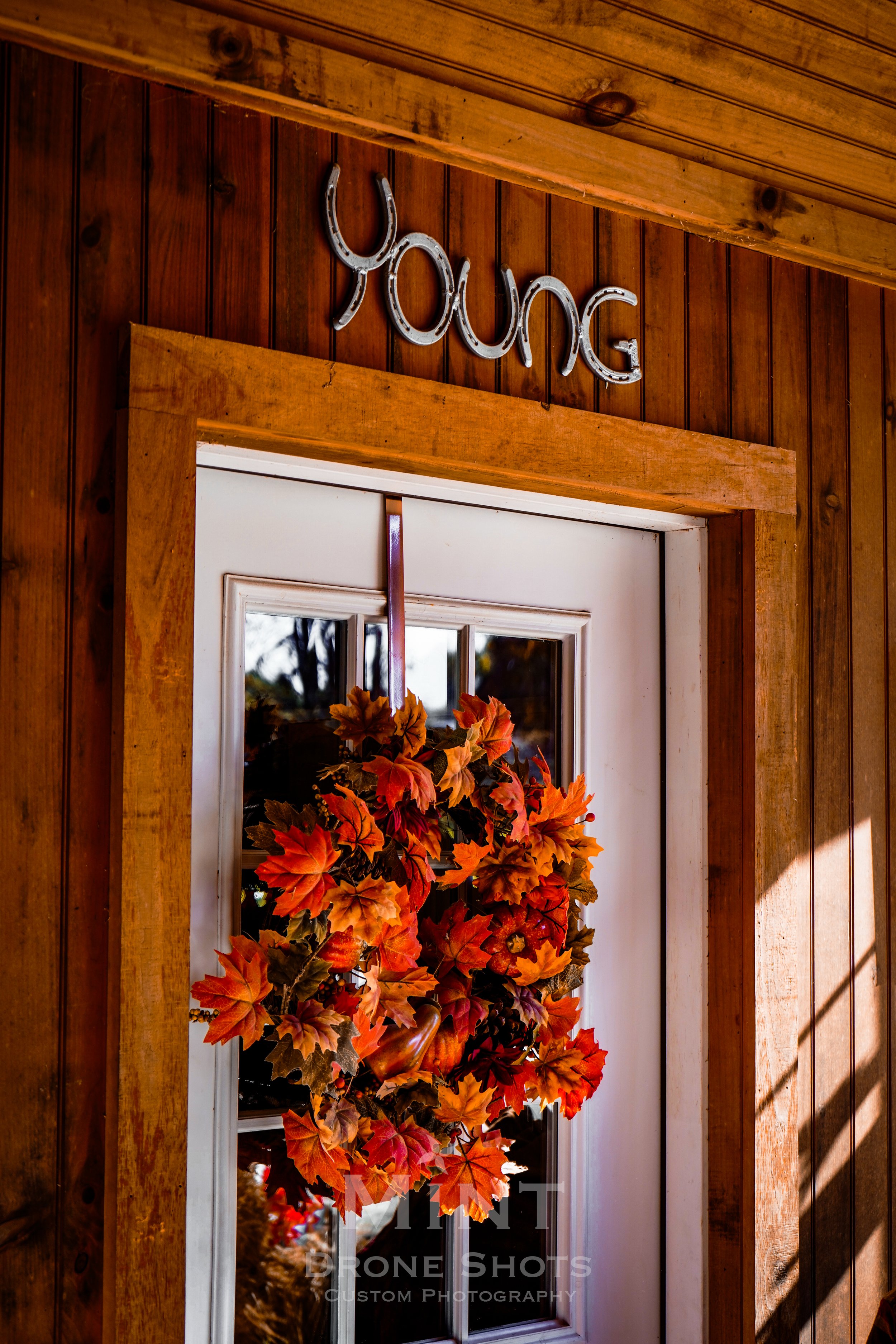 Entrance door with autumn wreath and vintage-style sign