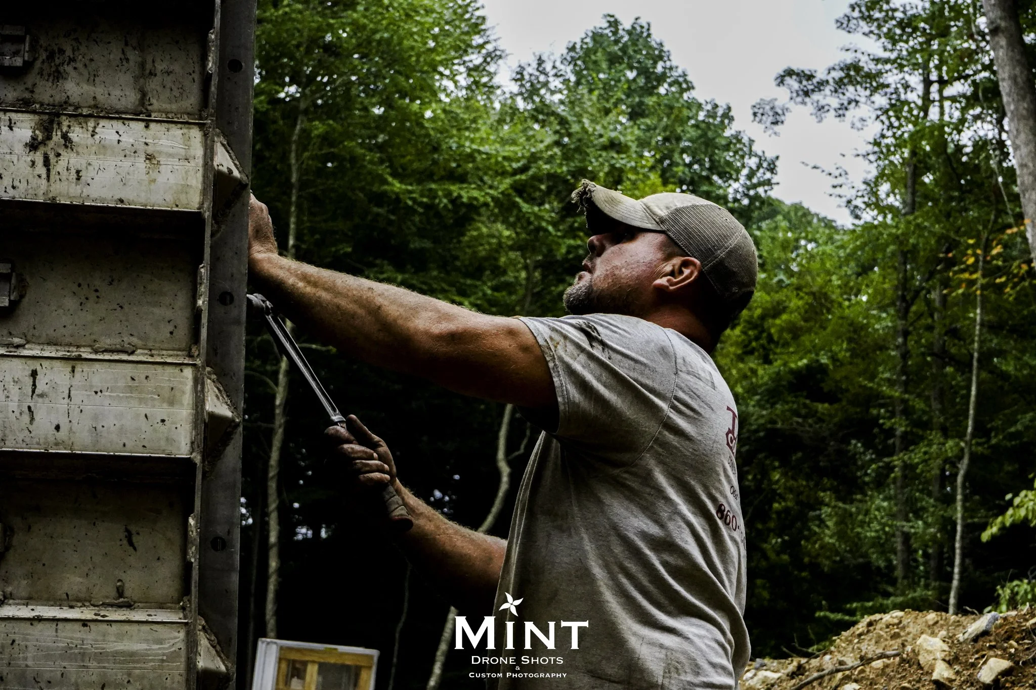 Construction worker tightening bolts on a metal structure at a construction site.