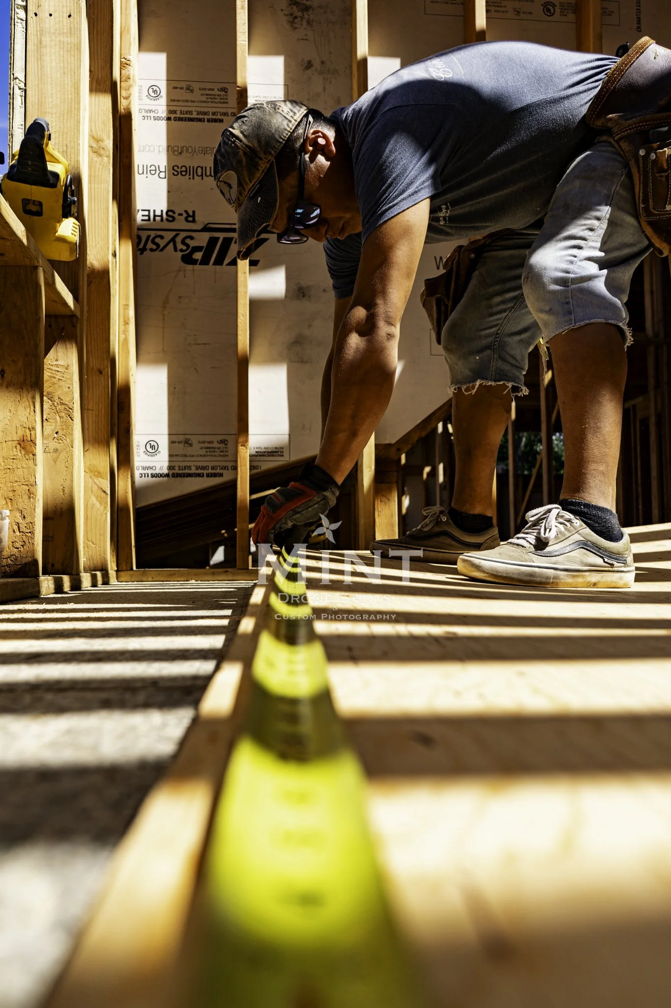 Construction worker measuring wood frame inside building structure.