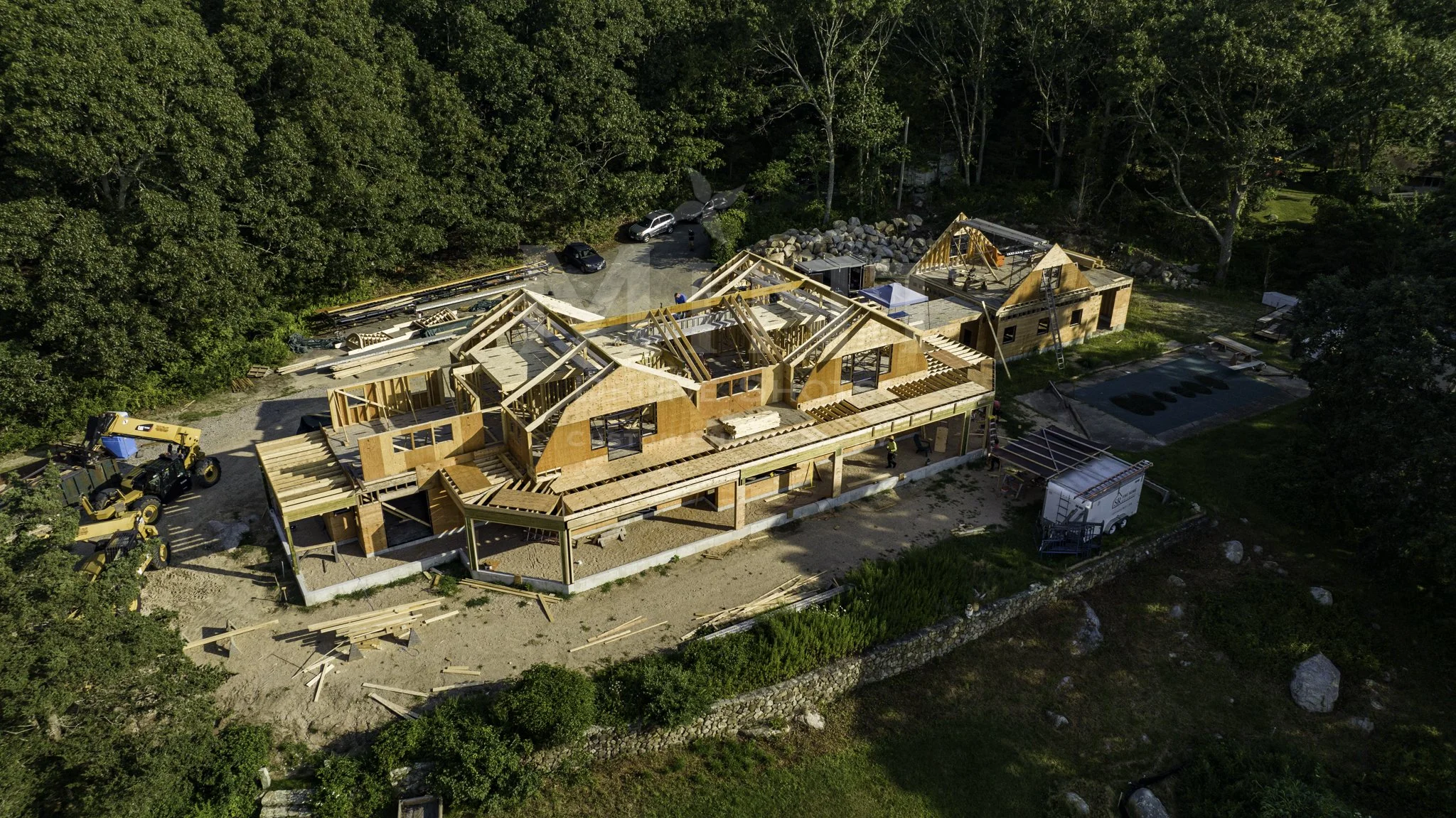Aerial view of a house under construction surrounded by trees.