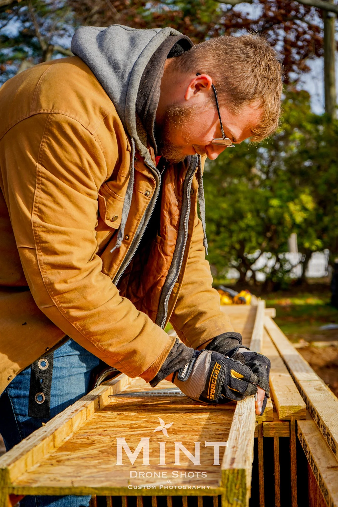 Construction worker assembling wooden structure outdoors